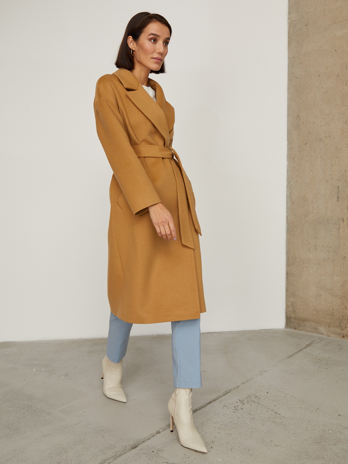 Пальто-халат из плотной шерсти. Модель прямого силуэтас английским воротником.Пальто дополнено двумя вместительными карманами,без застежки, с поясом из основного материала.

На модели размер XS