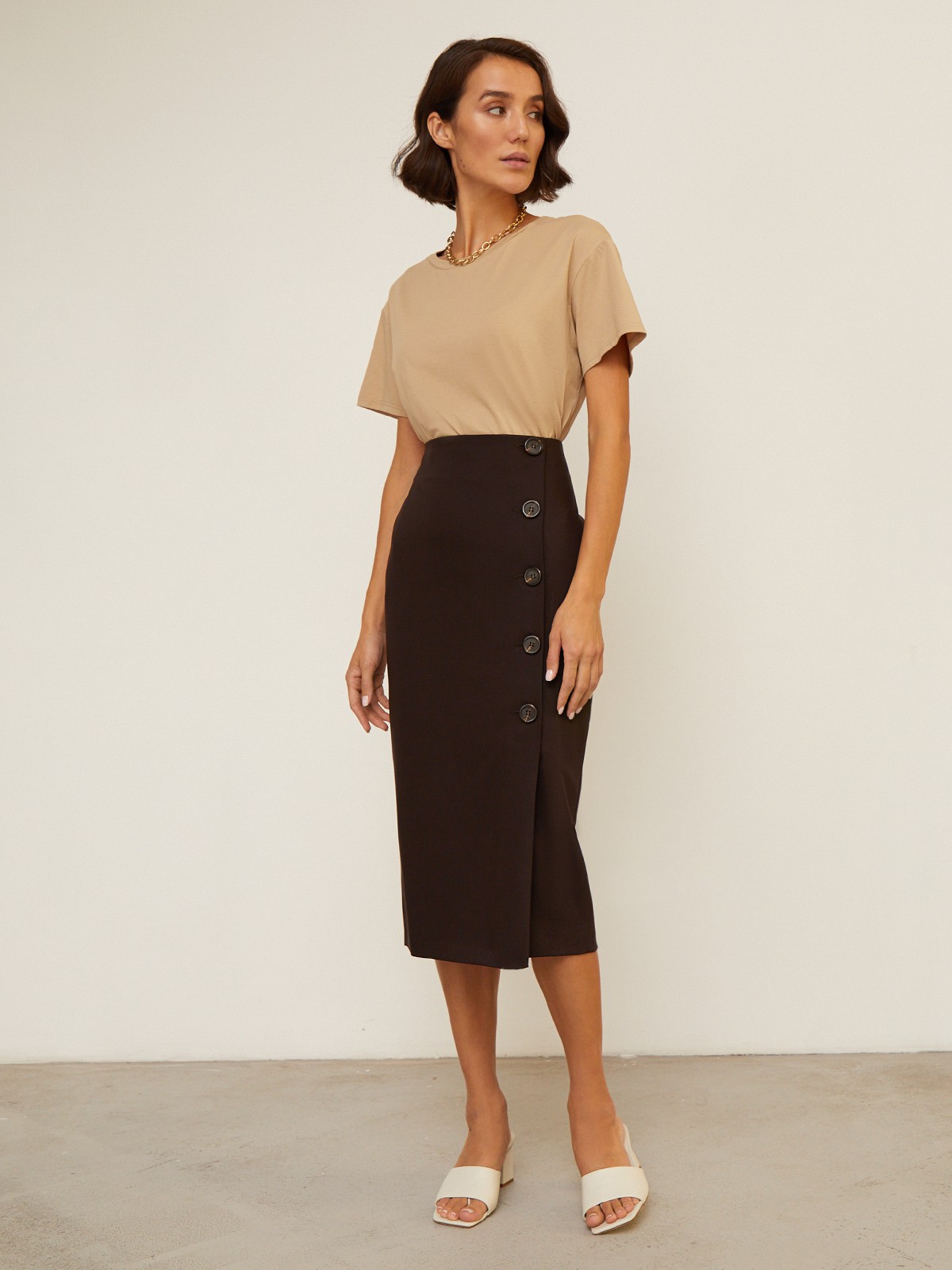 Юбка-карандаш зауженная к низу длины миди. Модель с потайной застежкой на спинке. Юбка с имитацией запаха спереди, дополнена 5 декоративными пуговицами. Образ хорошо дополнят тpикотaжные cвитeра или oбъемные рyбашки.

На модели размер XS