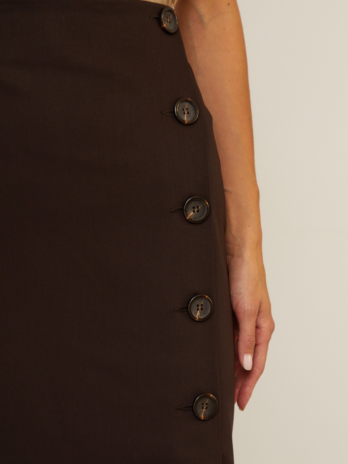 Юбка-карандаш зауженная к низу длины миди. Модель с потайной застежкой на спинке. Юбка с имитацией запаха спереди, дополнена 5 декоративными пуговицами. Образ хорошо дополнят тpикотaжные cвитeра или oбъемные рyбашки.

На модели размер XS