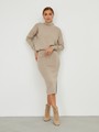 Костюм из вязанного трикотажа, состоящий из юбки с кофтой. Юбка прямая, зауженная к низу. Дополнена разрезом по шву с левой стороны. Кофта прямая со спущенным плечом, дополнена воротником-стойкой.

На модели размер M/L