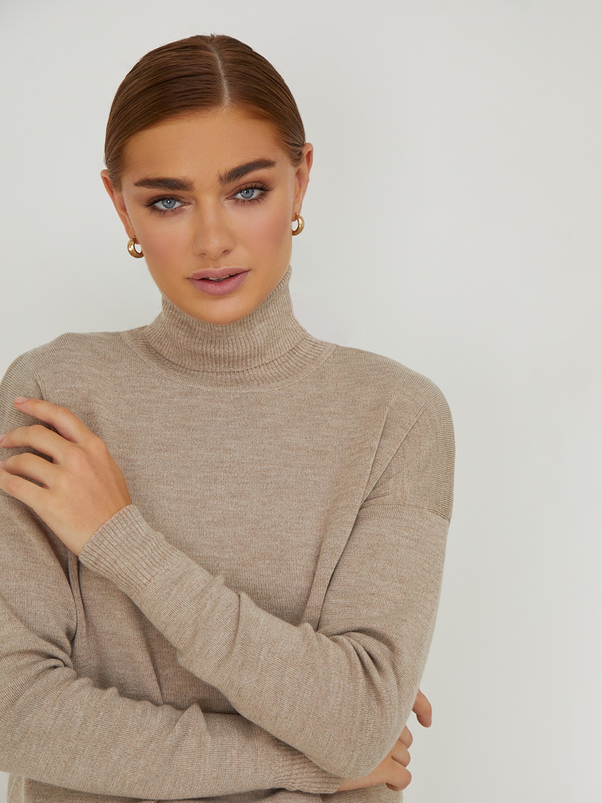 Костюм из вязанного трикотажа, состоящий из юбки с кофтой. Юбка прямая, зауженная к низу. Дополнена разрезом по шву с левой стороны. Кофта прямая со спущенным плечом, дополнена воротником-стойкой.

На модели размер M/L