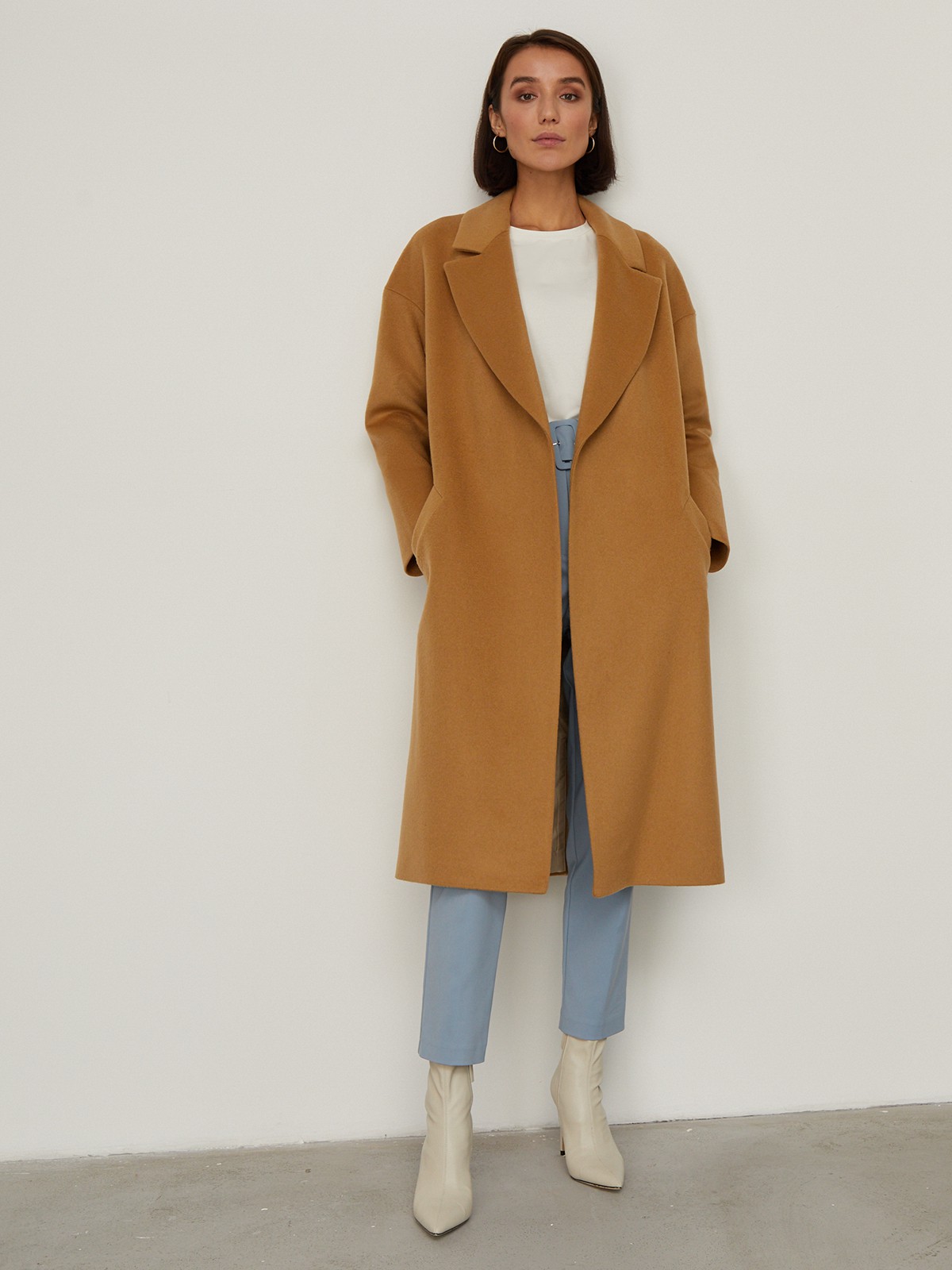 Пальто-халат из плотной шерсти. Модель прямого силуэтас английским воротником.Пальто дополнено двумя вместительными карманами,без застежки, с поясом из основного материала.

На модели размер XS