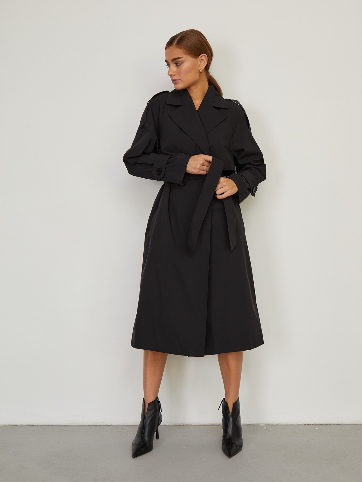 Демисезонный двубортный плащпрямого силуэта. Модель дополнена съемным поясом, отлетной кокеткой на груди и хлястиками на рукавах. Тренч свободного кроя с рукавами реглан станет незаменимой вещью в вашем гардеробе при создании смелых городских образов.

На модели размер XS/S