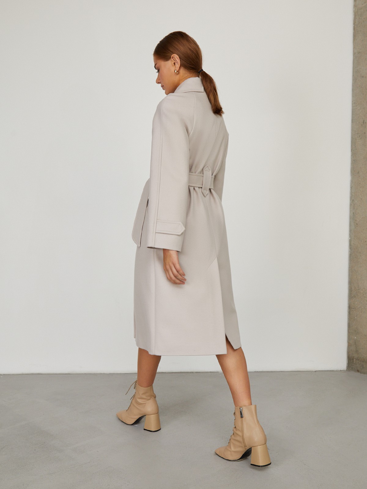 Пальто-халат длины миди с клапанами на карманах, рукавом реглан. Дополнено декоративными отстрочками и воротником-стойка с фигурным вырезом. Данная модель красиво подчеркивает женственные формы за счет пояса.

На модели размер XS