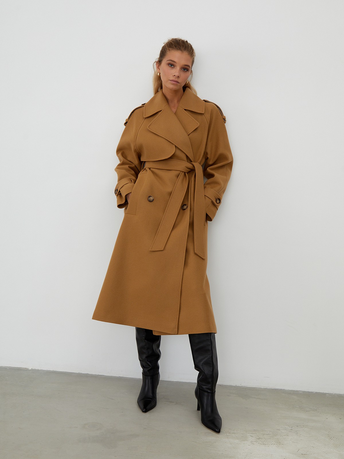 Двубортное пальто-тренч свободного кроя с застежкой на пуговицы. Дополнено поясом, пряжкой на манжетах и погонами в тон изделия. Модный силуэт оверсайз позволяет создавать дерзкие образы в стиле80-х гг.

На модели размер XS