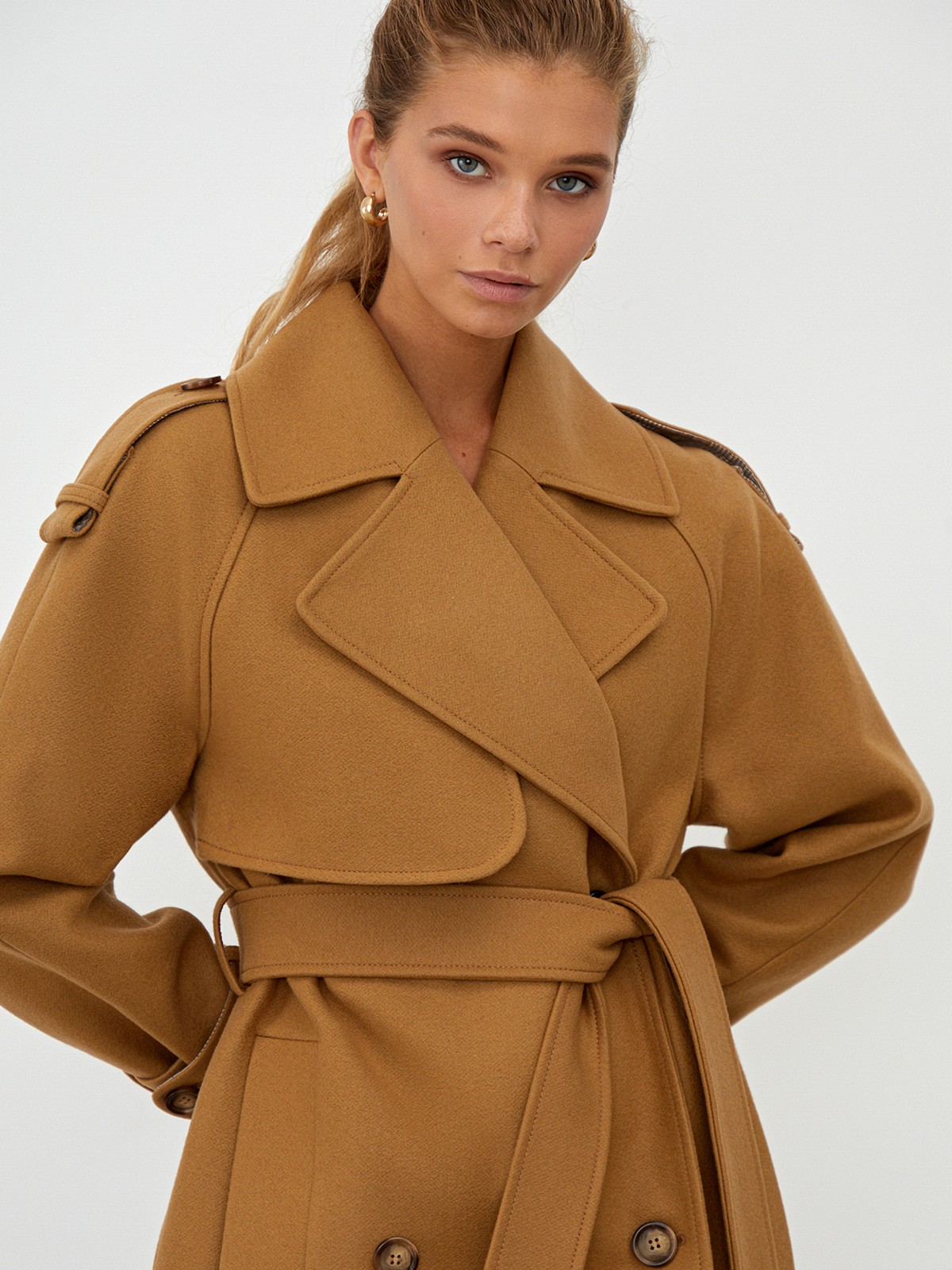 Двубортное пальто-тренч свободного кроя с застежкой на пуговицы. Дополнено поясом, пряжкой на манжетах и погонами в тон изделия. Модный силуэт оверсайз позволяет создавать дерзкие образы в стиле80-х гг.

На модели размер XS