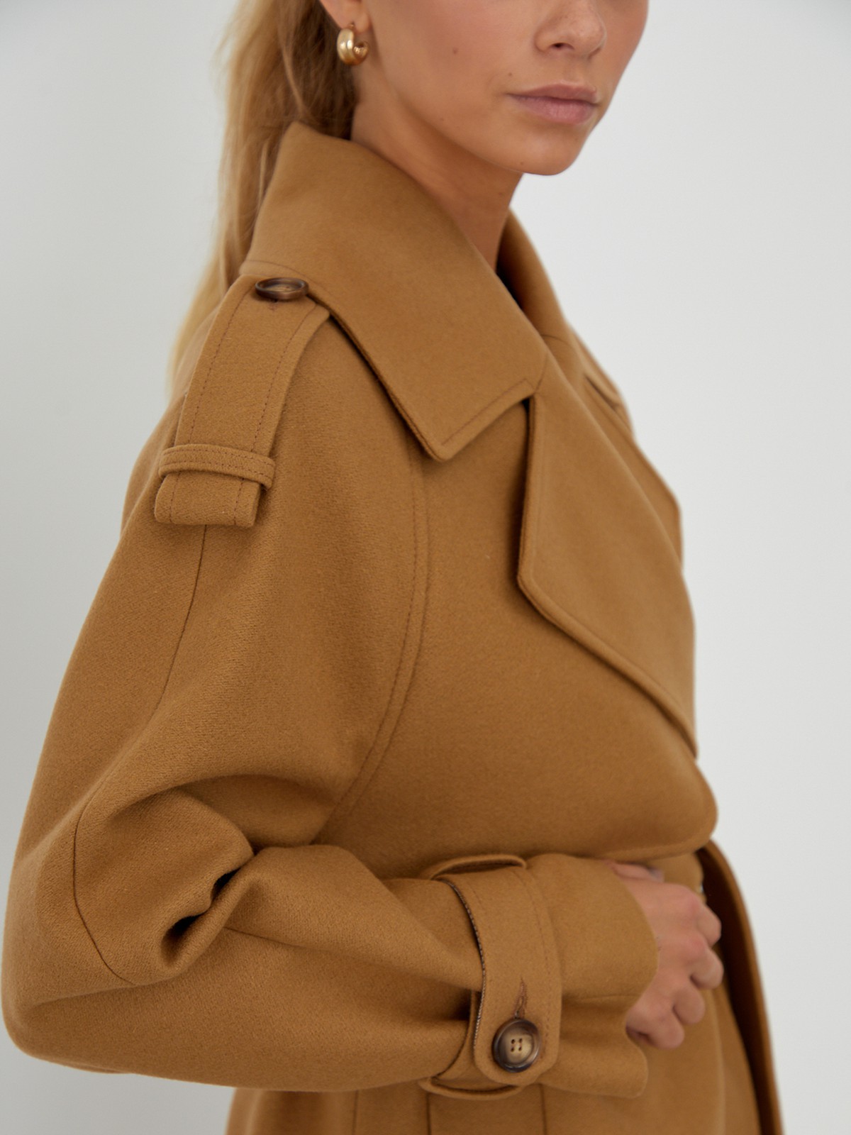 Двубортное пальто-тренч свободного кроя с застежкой на пуговицы. Дополнено поясом, пряжкой на манжетах и погонами в тон изделия. Модный силуэт оверсайз позволяет создавать дерзкие образы в стиле80-х гг.

На модели размер XS