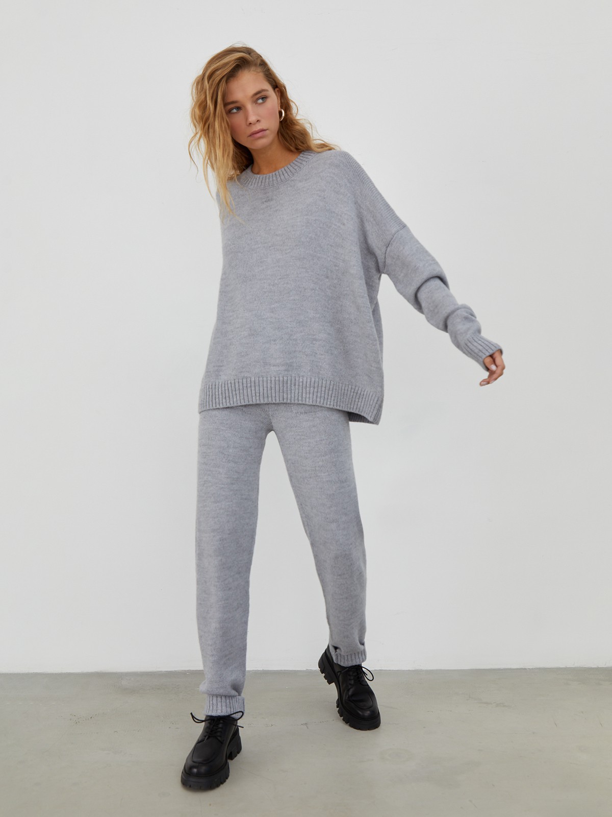 Костюм из вязанного трикотажа, состоящий из кофты и брюк. Кофта свободного силуэта со спущенным плечом. Брюки прямые с резинкой на поясе, зауженные к низу.

На модели размер one size