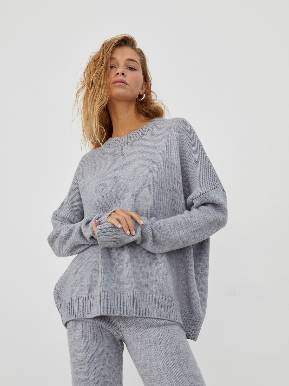 Костюм из вязанного трикотажа, состоящий из кофты и брюк. Кофта свободного силуэта со спущенным плечом. Брюки прямые с резинкой на поясе, зауженные к низу.

На модели размер one size