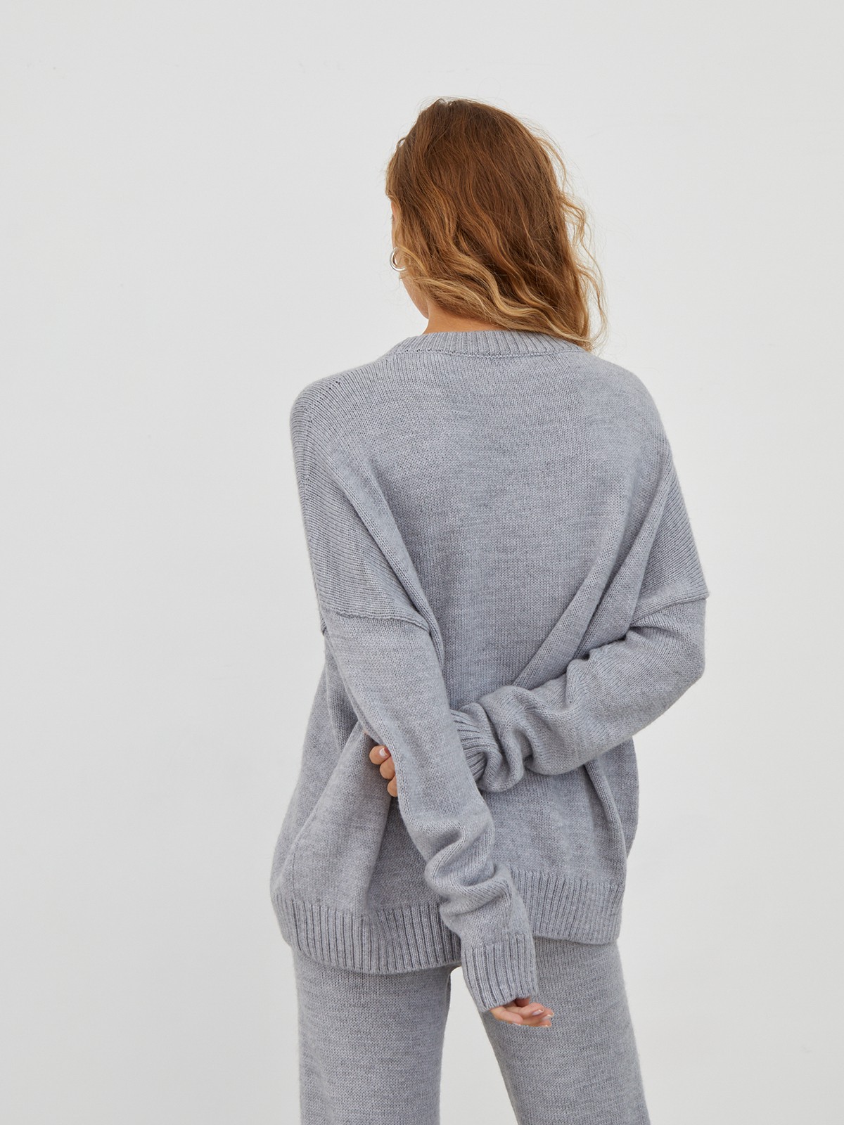 Костюм из вязанного трикотажа, состоящий из кофты и брюк. Кофта свободного силуэта со спущенным плечом. Брюки прямые с резинкой на поясе, зауженные к низу.

На модели размер one size