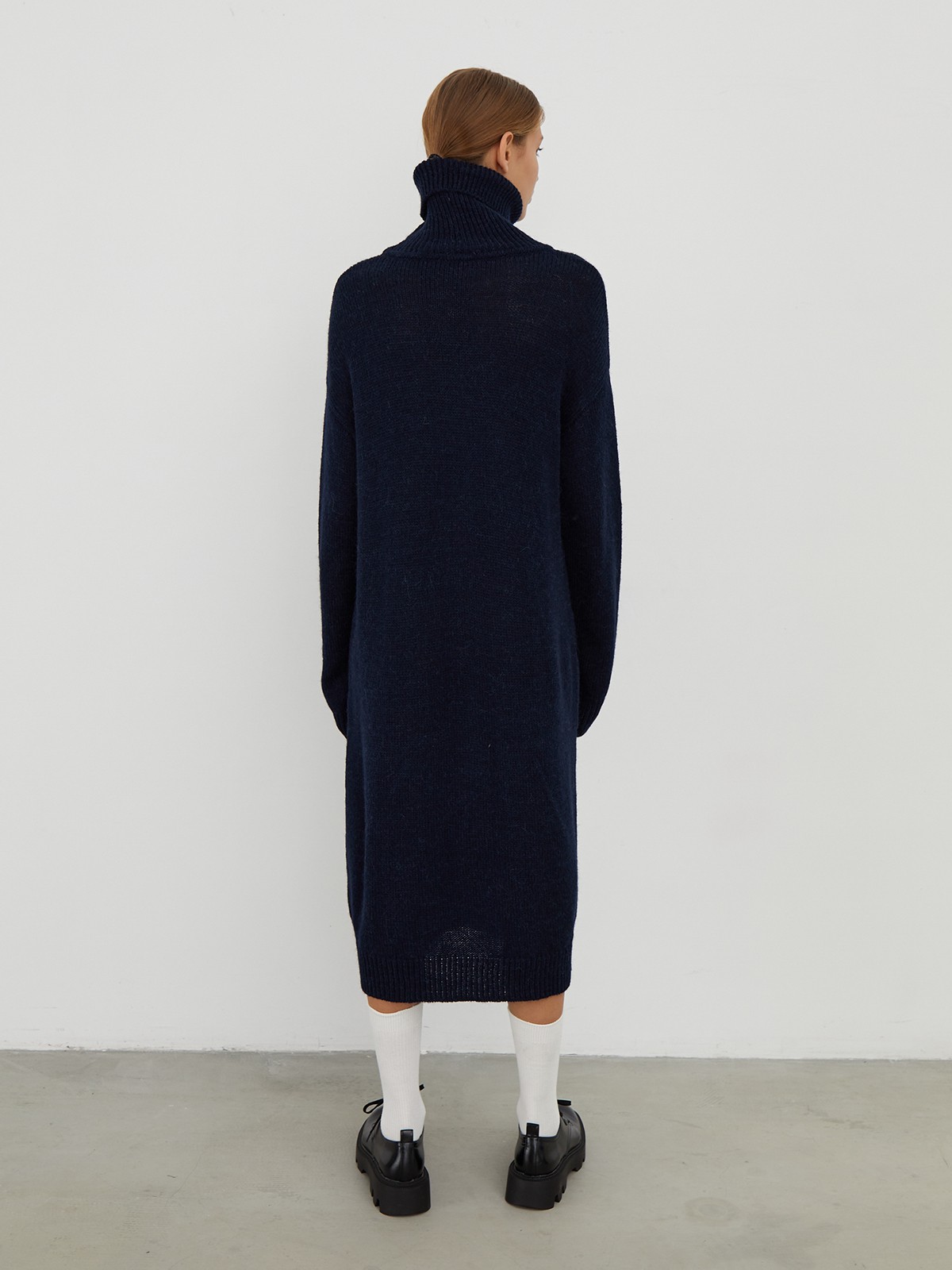 Трикотажное платье длины миди прямого кроя. Дополнено широким высоким воротом. По низу рукава и низу изделия притачан манжет, что создает удобство при ношении платья. Идеальный вариант для прохладных зимнихпрогулок и уютных посиделок с друзьями.