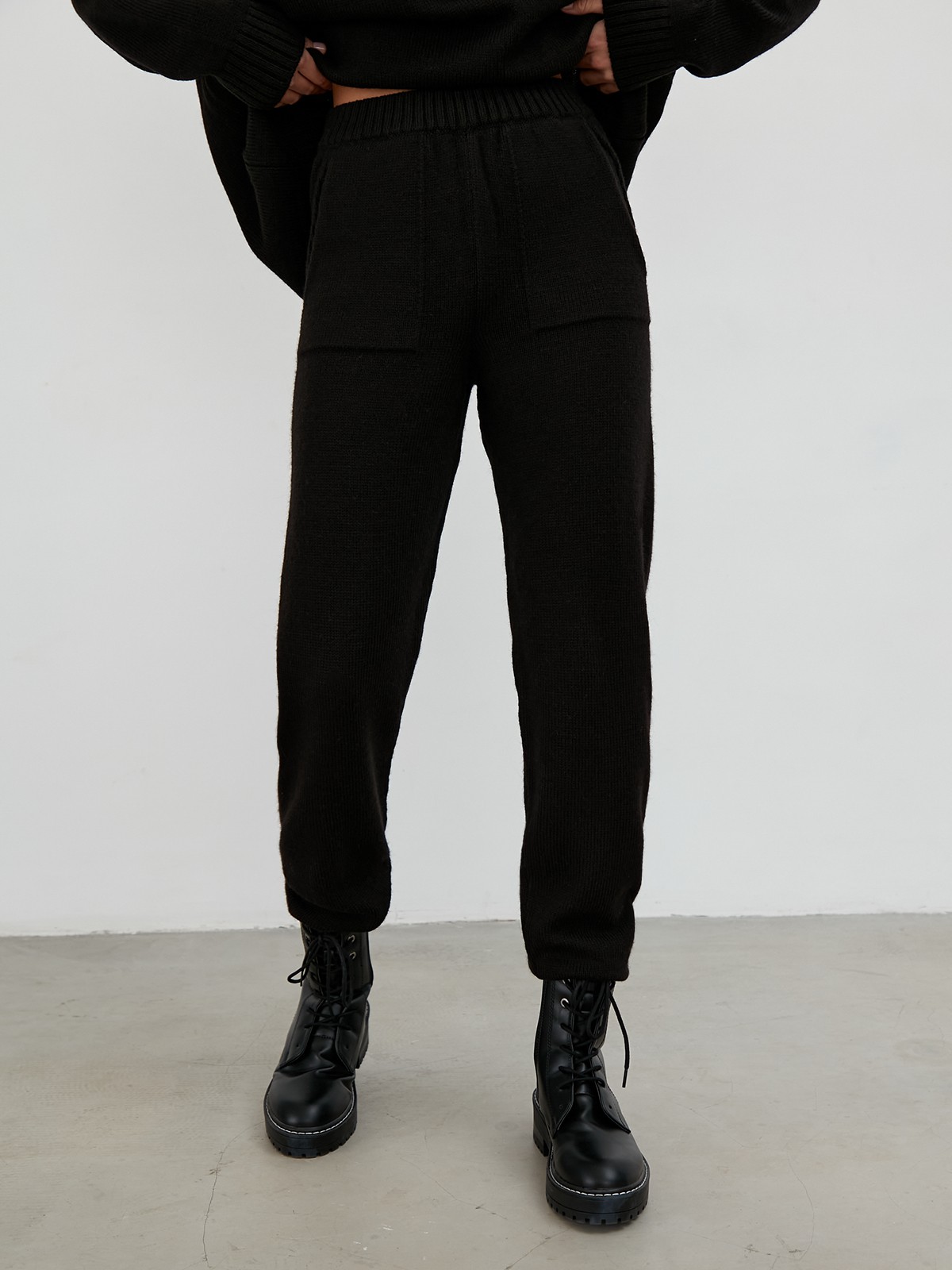 Костюм из вязанного трикотажа, состоящий из кофты и брюк. Кофта свободного силуэта со спущенным плечом. Брюки прямые с резинкой на поясе, зауженные к низу.

На модели размер one size