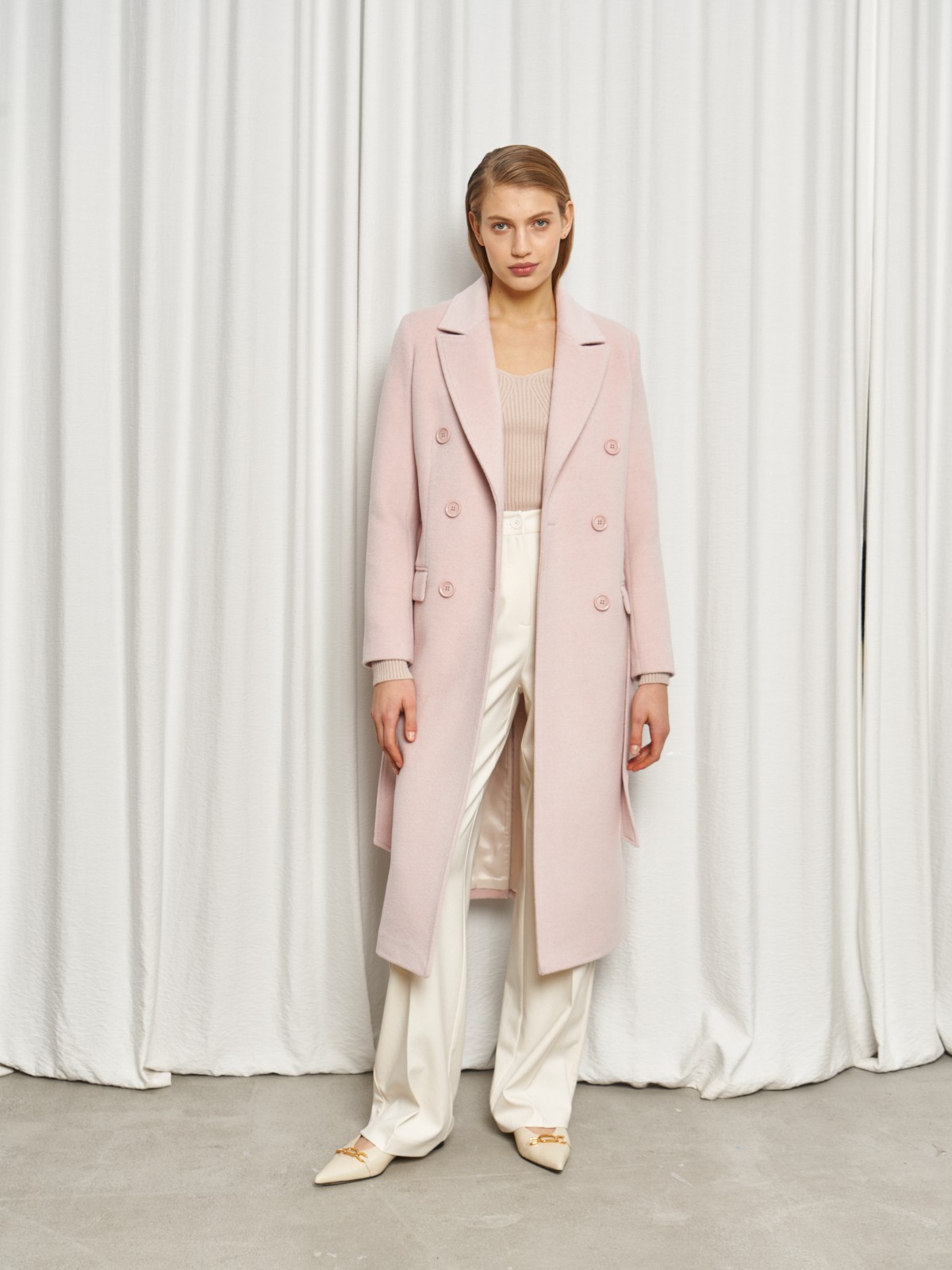 Классическое пальто двубортного кроя с втачными рукавами и широкими лацканами. Карманные клапаны по бокам, пуговицы в тон.

На модели размер XS