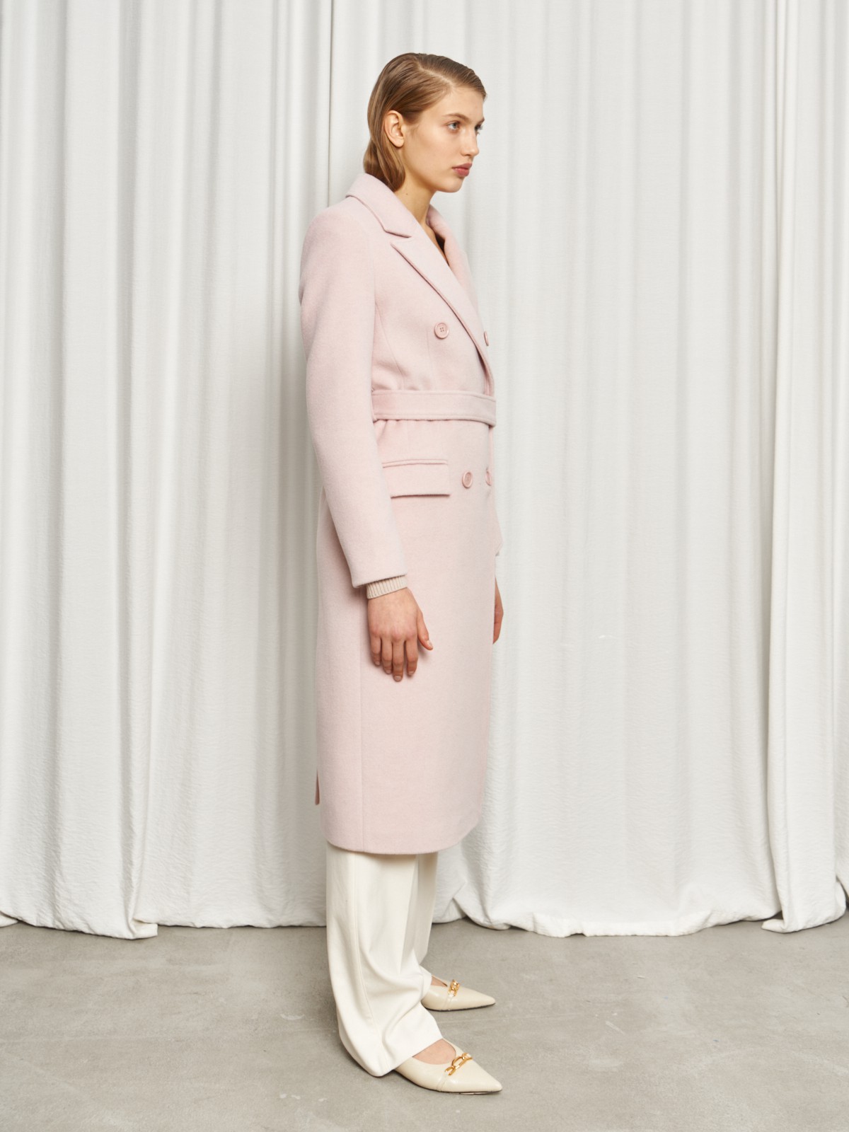 Классическое пальто двубортного кроя с втачными рукавами и широкими лацканами. Карманные клапаны по бокам, пуговицы в тон.

На модели размер XS