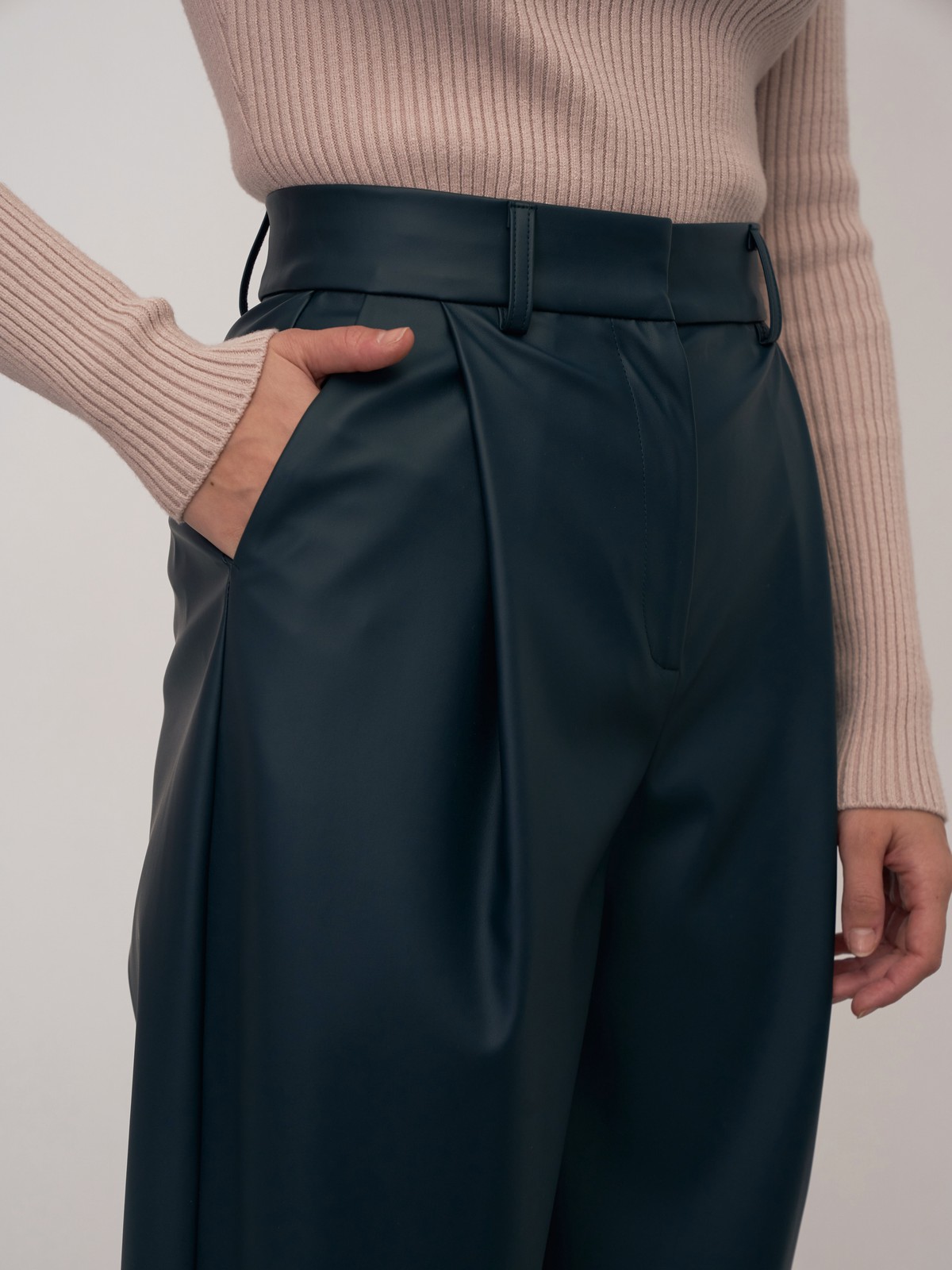 Брюки-бананы из эко-кожи выполнены из эко-кожи и оформлены мягкими сборками от пояса со шлевками и скошенными карманами по бокам.

На модели размер XS