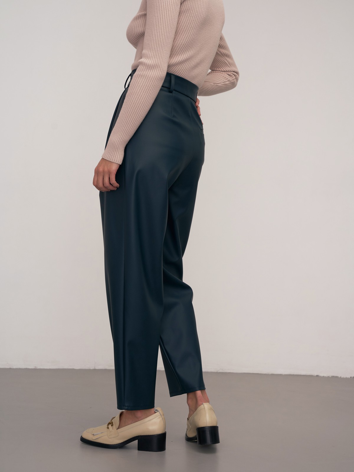 Брюки-бананы из эко-кожи выполнены из эко-кожи и оформлены мягкими сборками от пояса со шлевками и скошенными карманами по бокам.

На модели размер XS