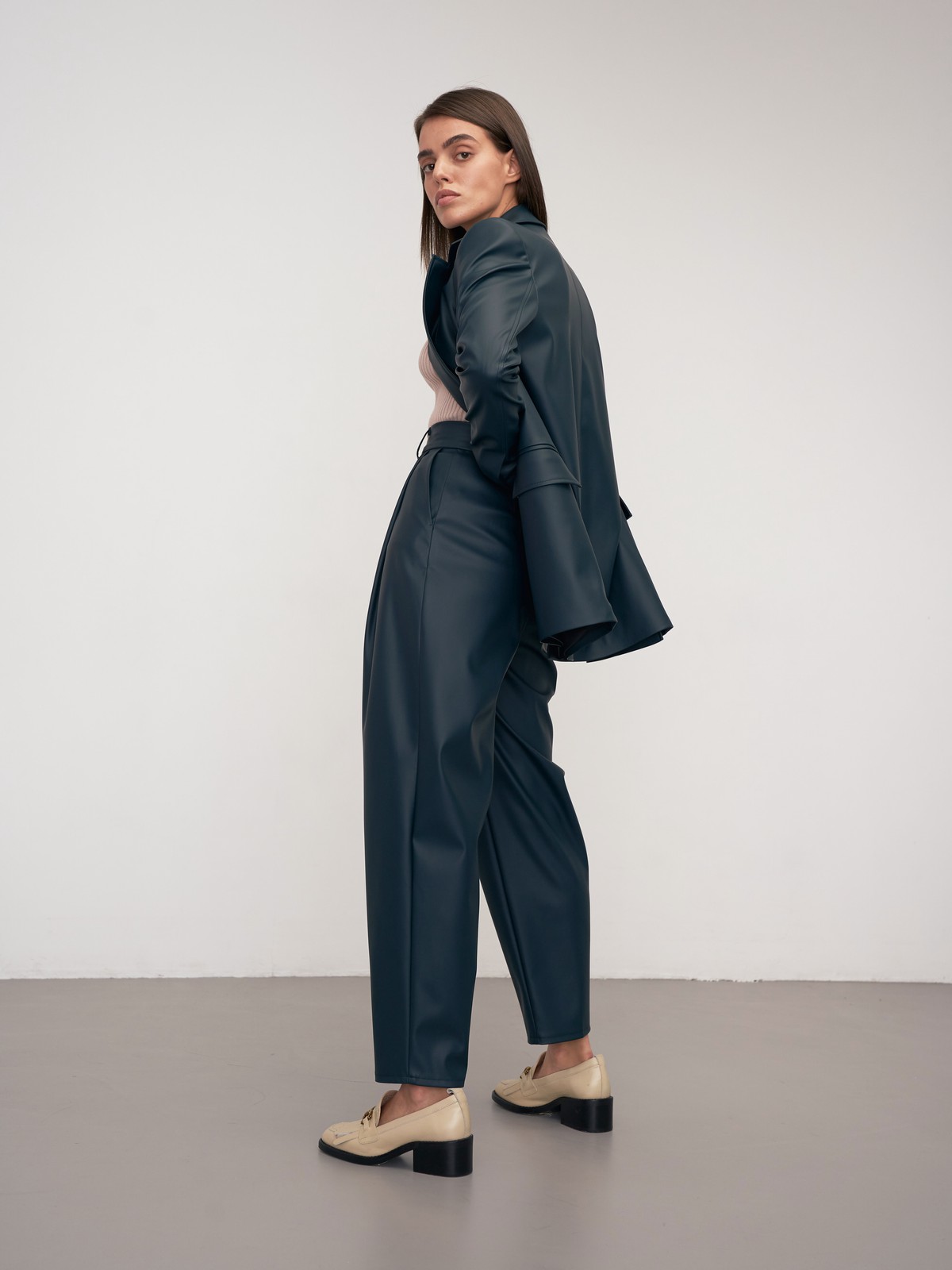 Брюки-бананы из эко-кожи выполнены из эко-кожи и оформлены мягкими сборками от пояса со шлевками и скошенными карманами по бокам.

На модели размер XS