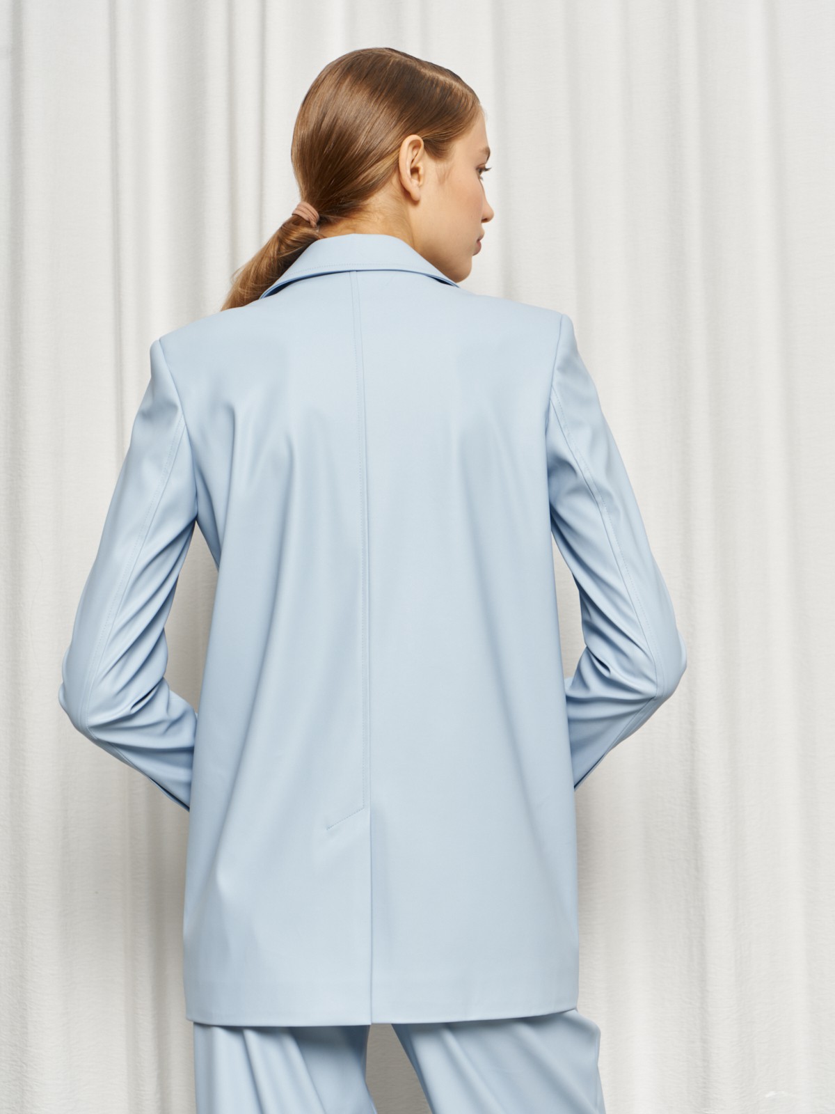 Жакет двубортного кроя выполнен из эко-кожи и оформлен заостренными лацканами, акцентированной плечевой линией и карманными клапанами по бокам.

На модели размер XS