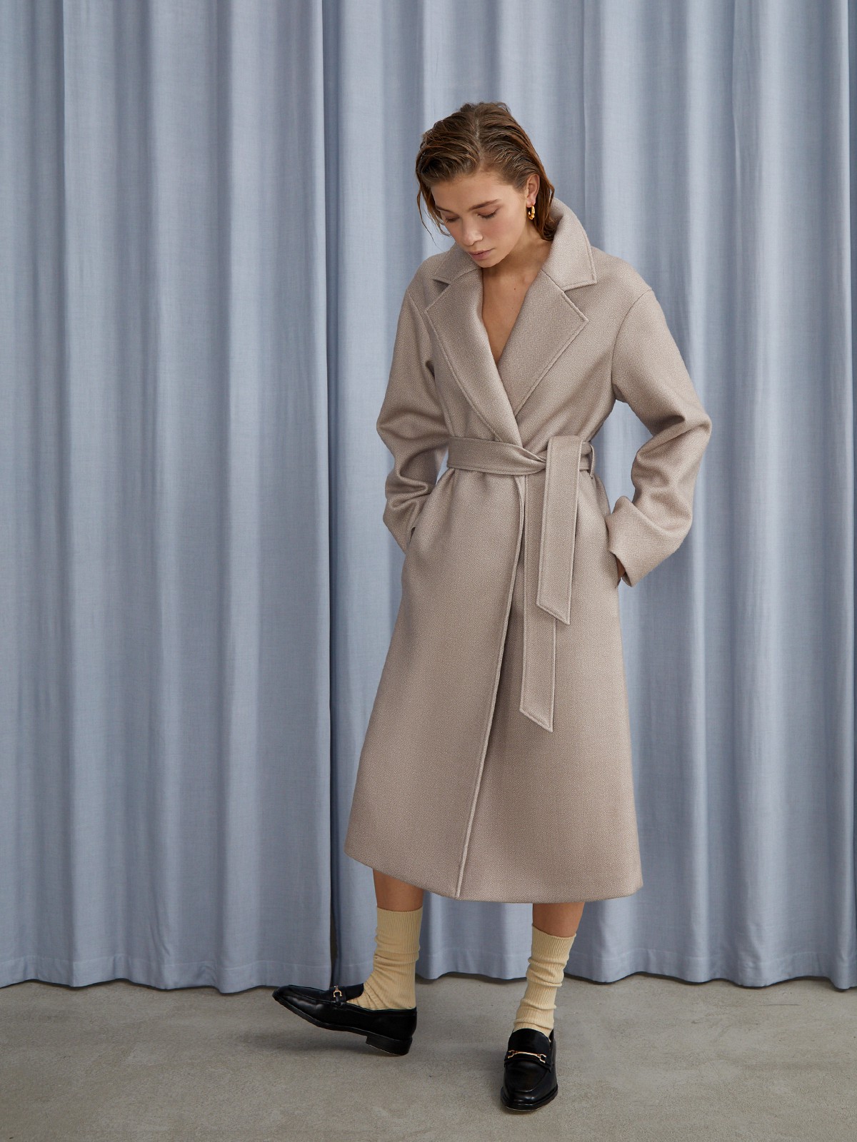 


Пальто oversize кроя выполнено из двусторонней ткани с прострочкой в тон. Лаконичная модель оформлена широкими лацканами и мягким поясом на талии. Покатая линия плеча для дополнительной элегантности.

На модели размер XS