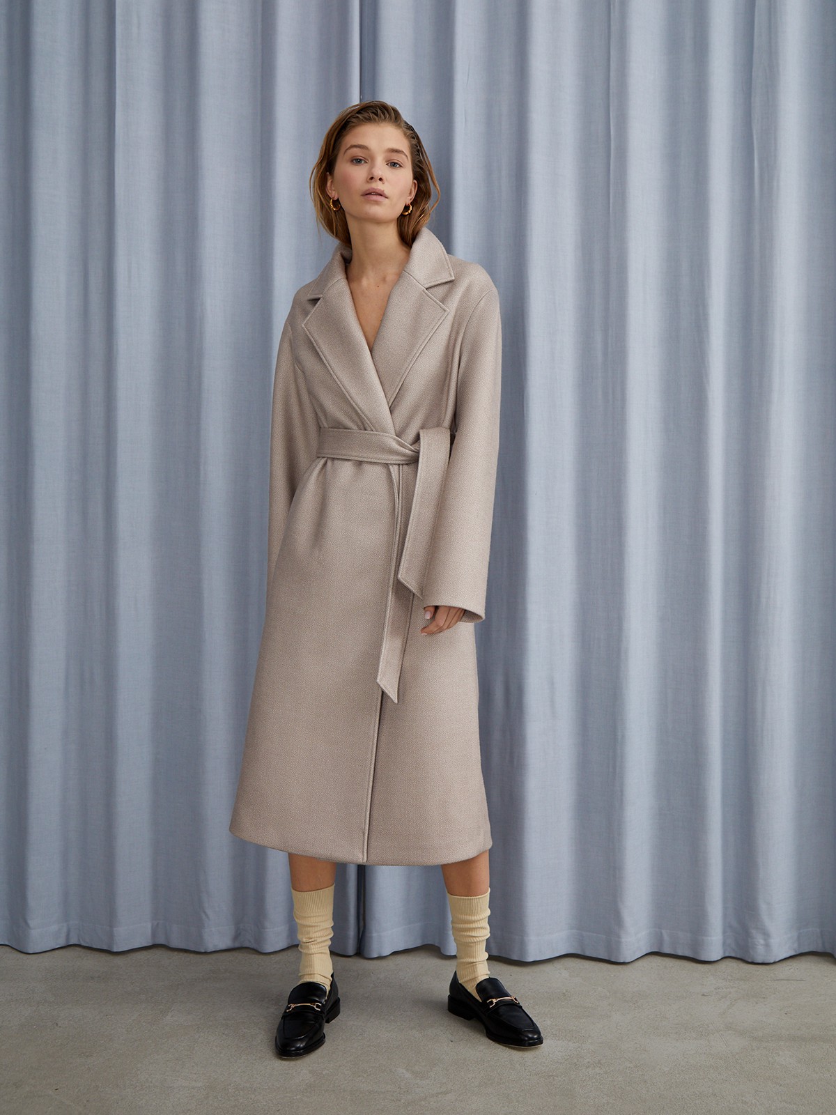 


Пальто oversize кроя выполнено из двусторонней ткани с прострочкой в тон. Лаконичная модель оформлена широкими лацканами и мягким поясом на талии. Покатая линия плеча для дополнительной элегантности.

На модели размер XS