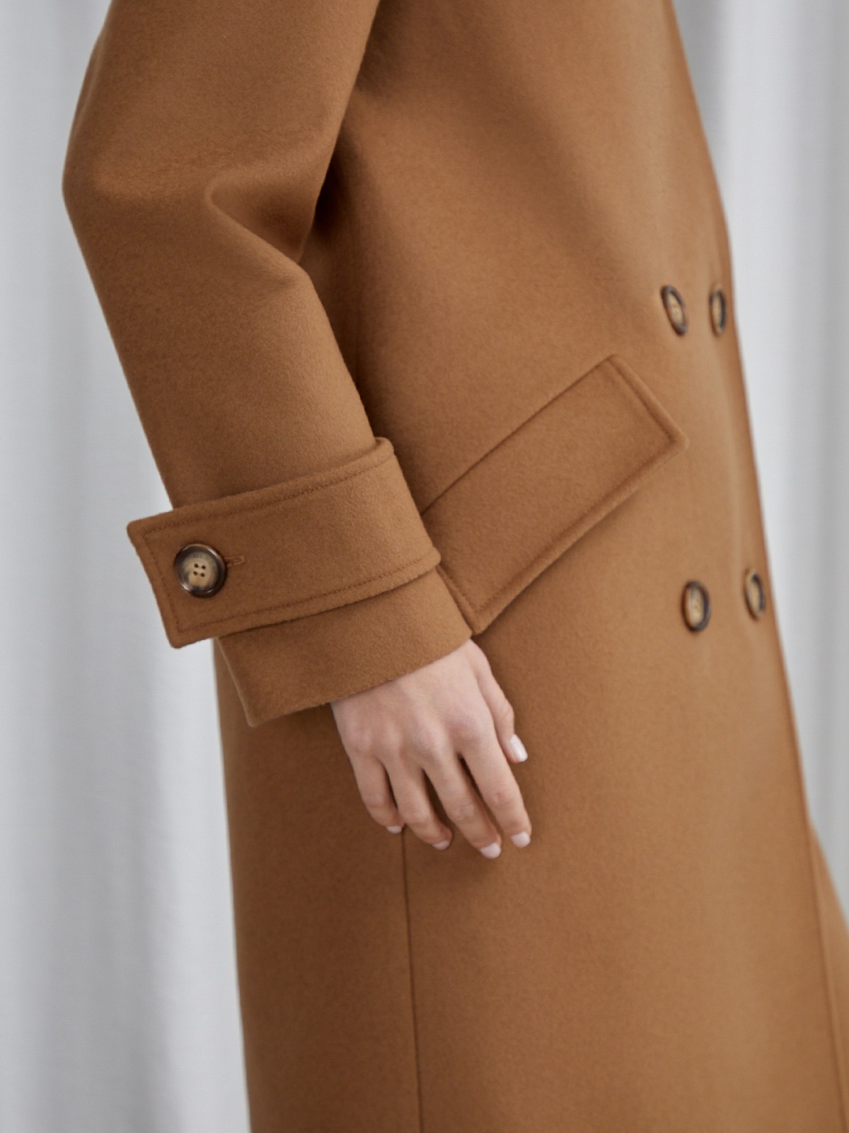 Пальто-кокон двубортного кроя с покатым рукавом и декоративными деталями: карманными клапанами, хлястиками на манжетах и лацканами у воротника.

На модели размер XS