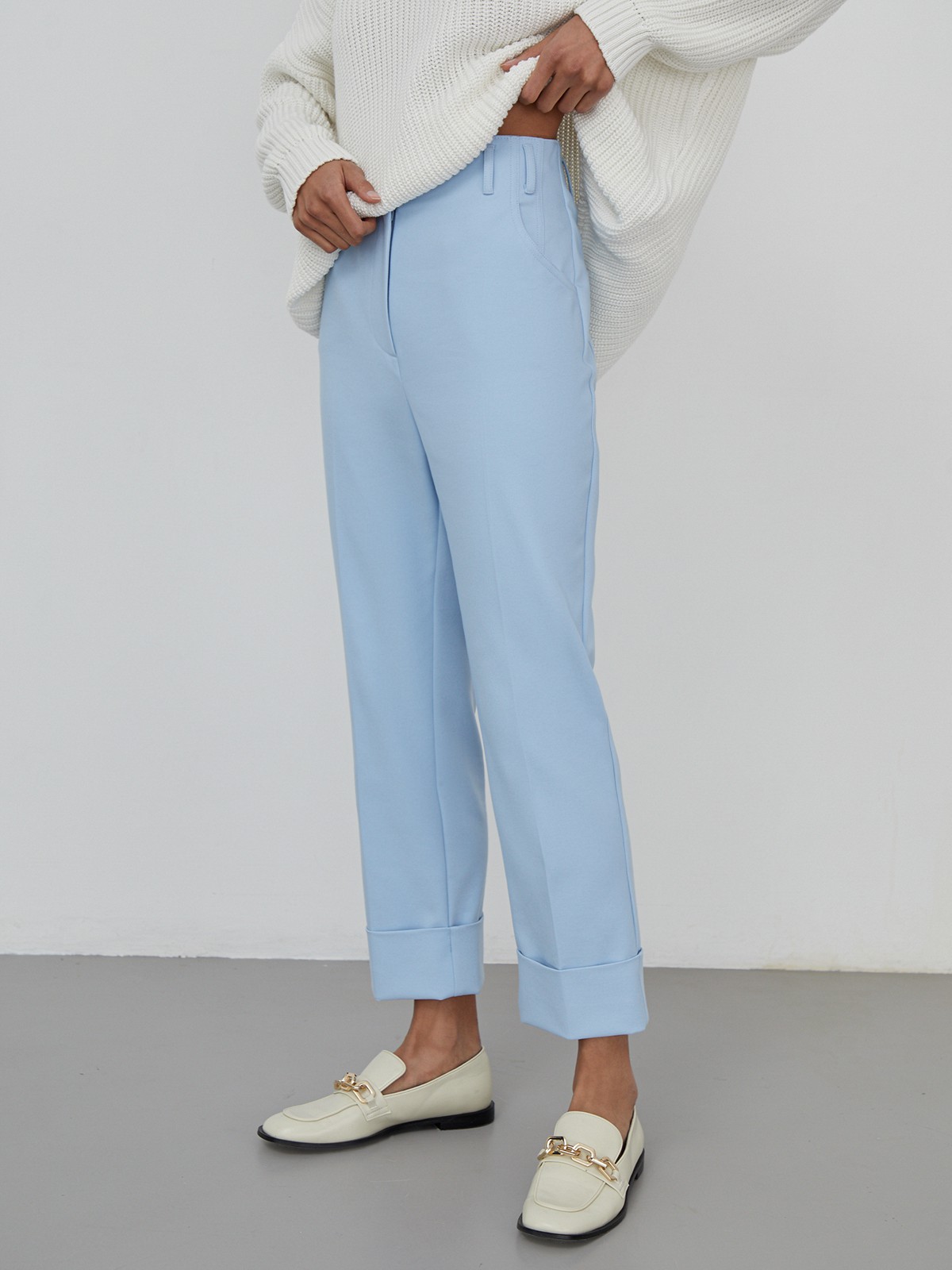 Костюмные брюки прямого кроя с прорезными боковыми карманами, шлевками для ремня и отворотами по низу.

На модели размер XS