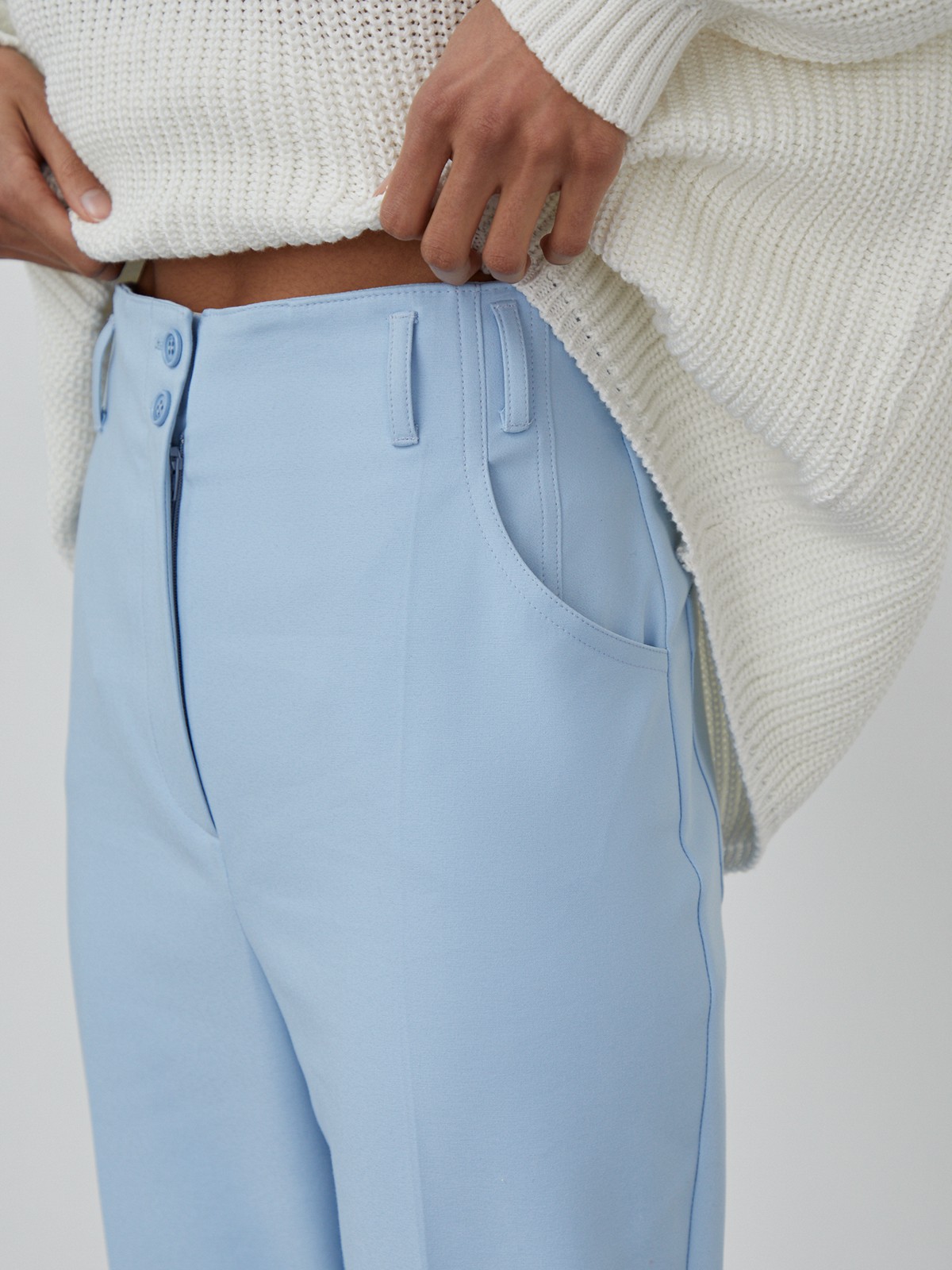 Костюмные брюки прямого кроя с прорезными боковыми карманами, шлевками для ремня и отворотами по низу.

На модели размер XS