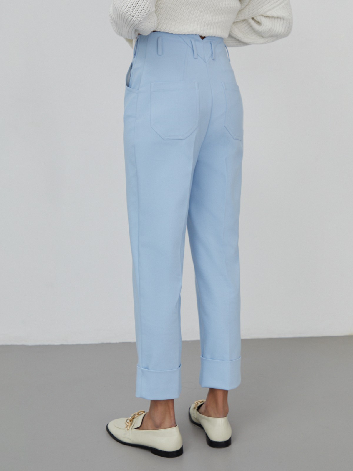 Костюмные брюки прямого кроя с прорезными боковыми карманами, шлевками для ремня и отворотами по низу.

На модели размер XS