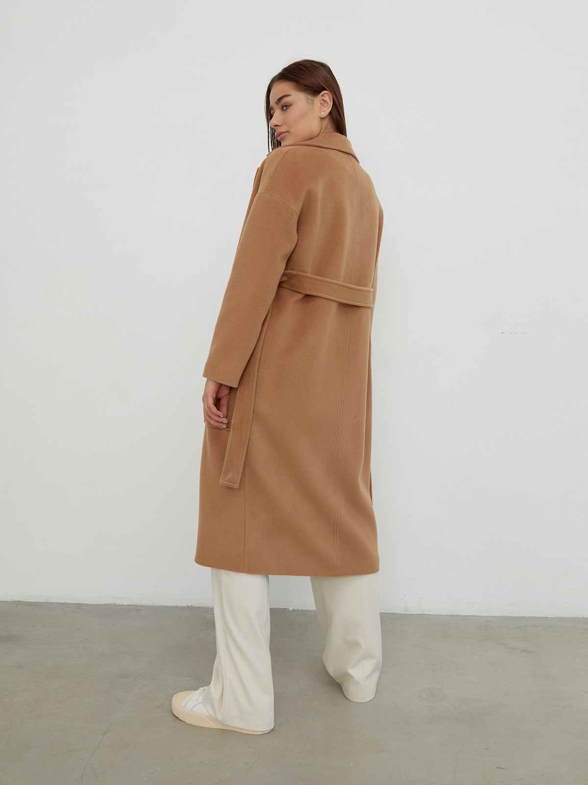 Пальто-халат однобортного кроя со спущенным рукавом и широкими лацканами. Глубокие накладные карманы по бокам, декоративная деталь на ремне.

На модели размер XS