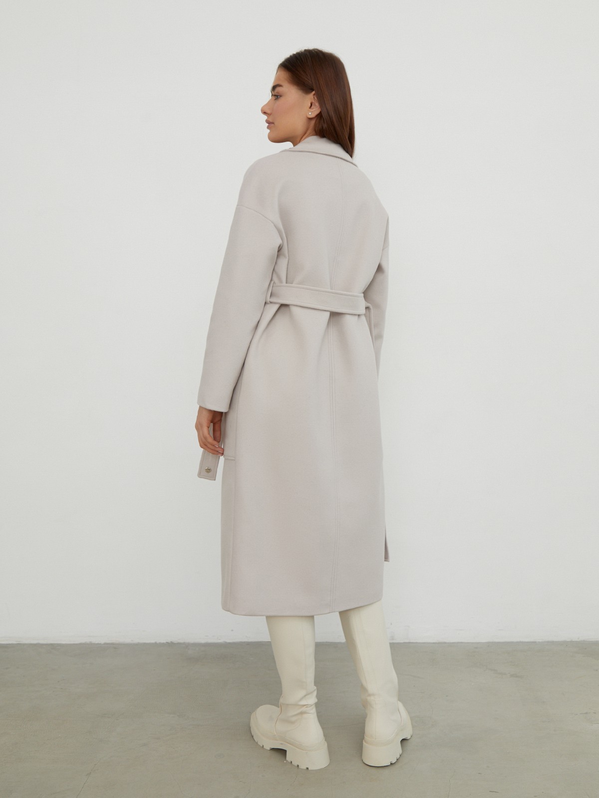 Пальто-халат однобортного кроя со спущенным рукавом и широкими лацканами. Глубокие накладные карманы по бокам, декоративная деталь на ремне.

На модели размер XS