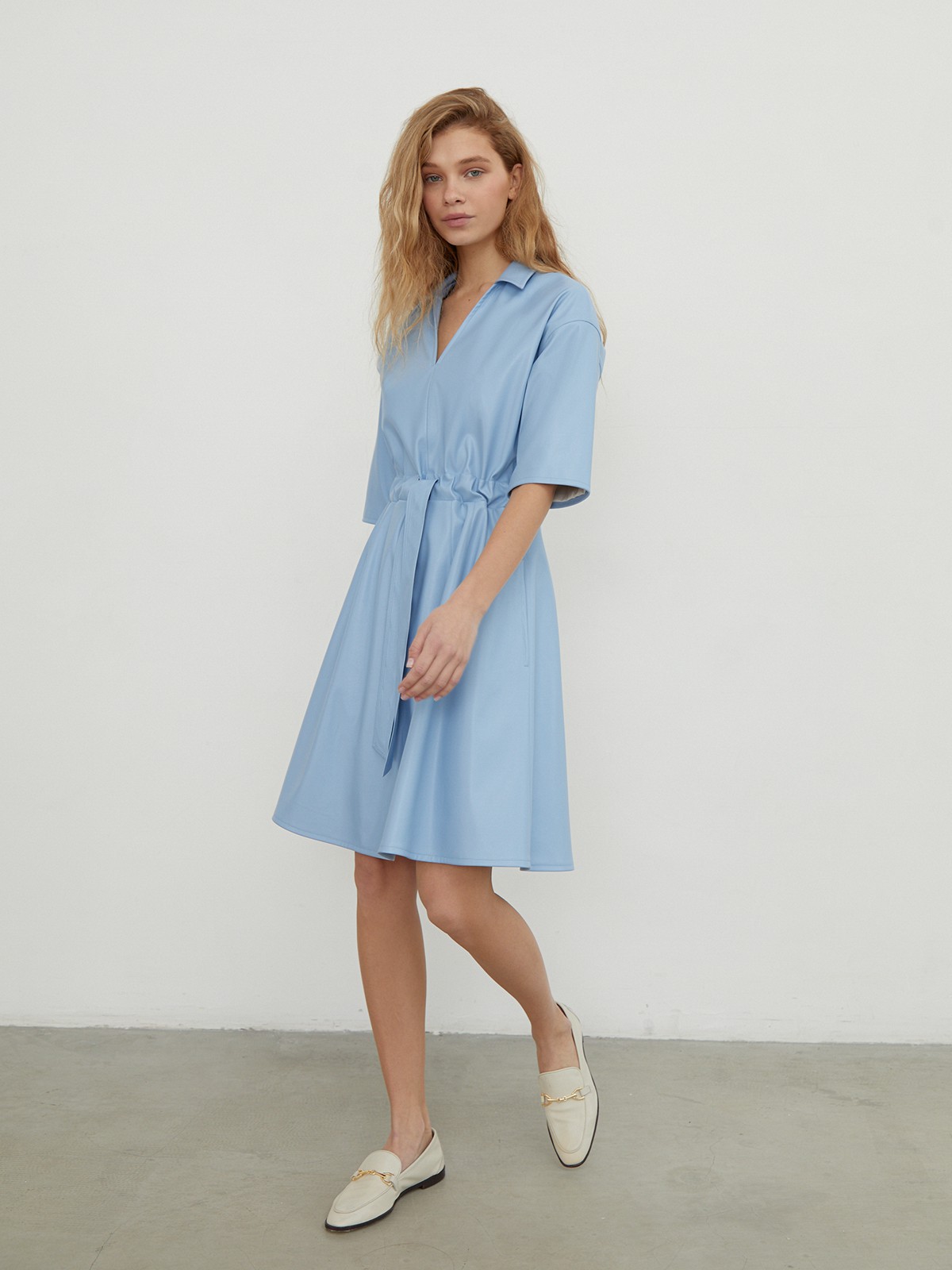 


Платье-рубашка выполнена из экокожи с гладкой матовой поверхностью. Модель оформлена отложным воротником, рукавами 1/2 и вшитым ремнем на талии.

На модели размер XS