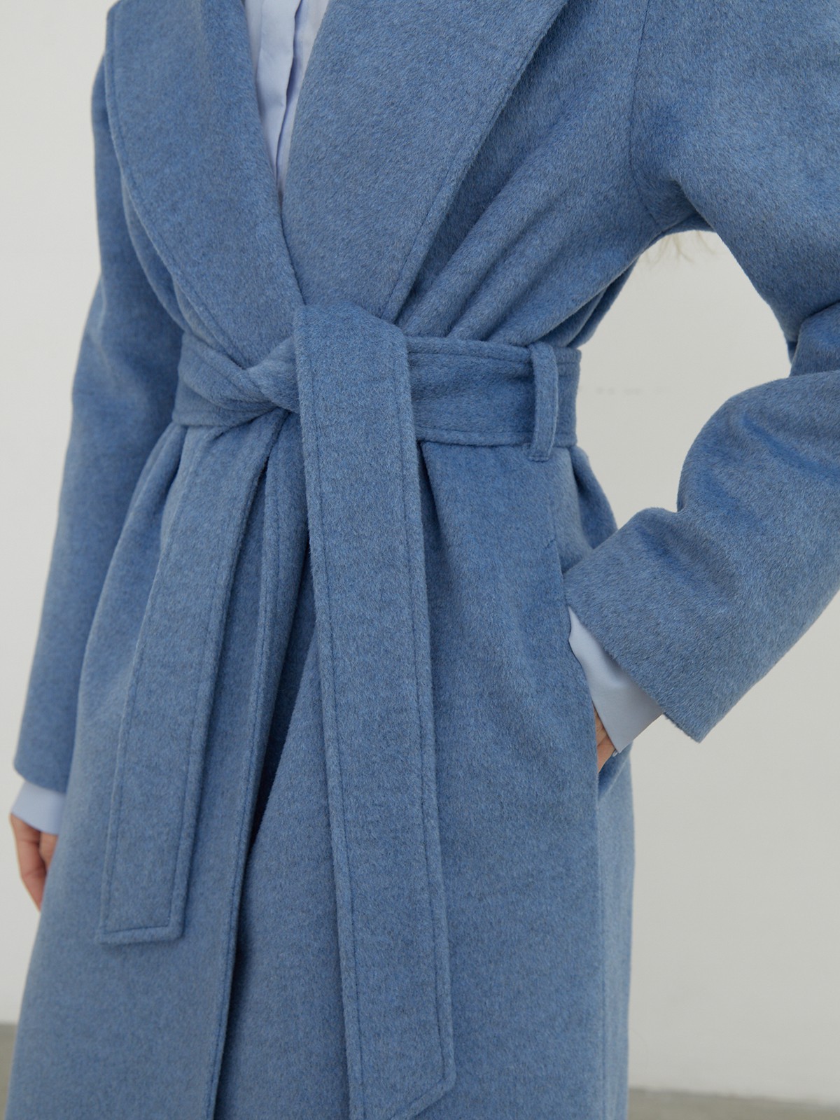 Утонченное пальто-халат А-силуэта. Модель дополнена широким поясом в тон основной ткани.

На модели размер XS