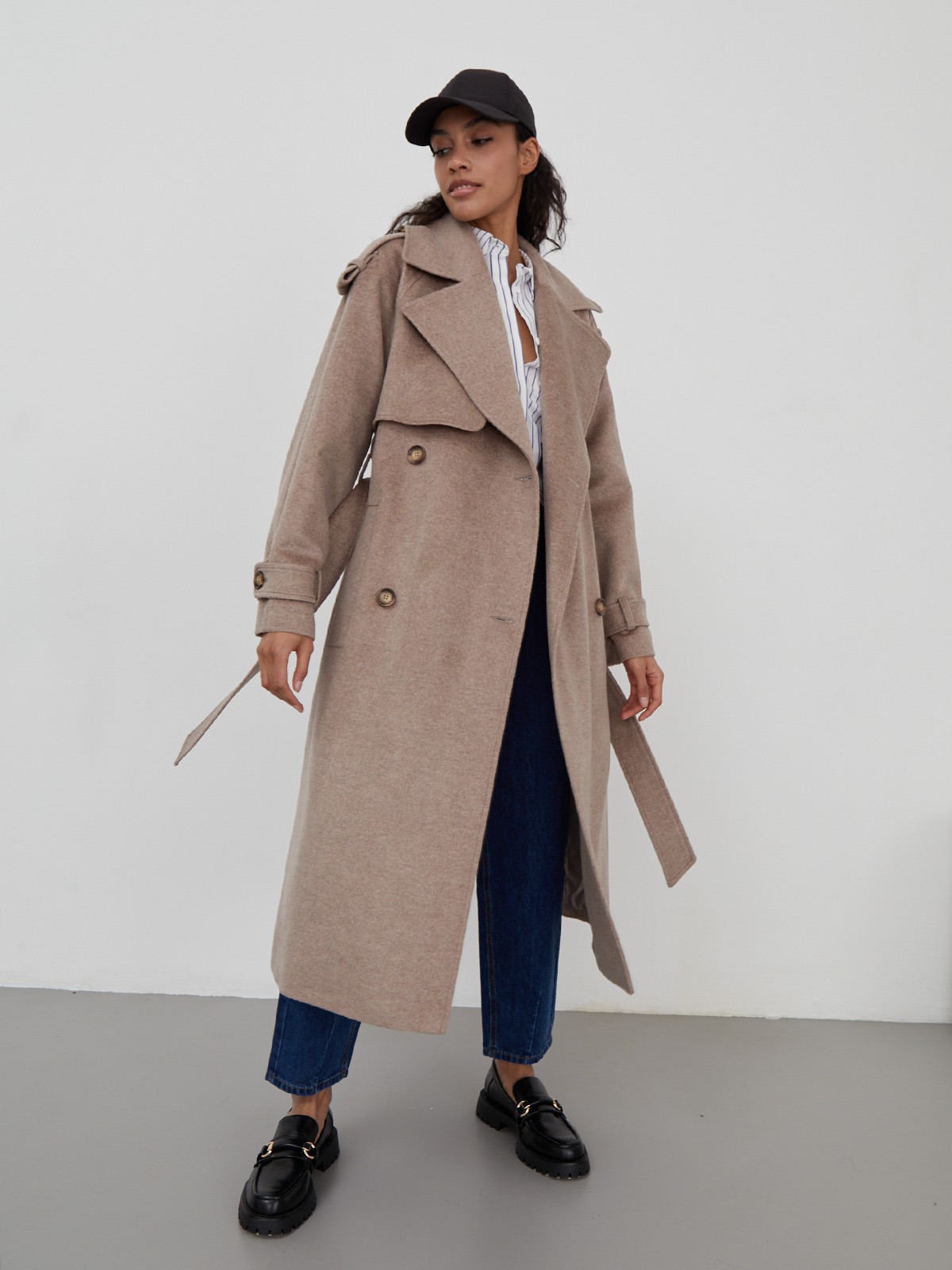 Двубортное пальто-тренч свободного кроя с застежкой на пуговицы. Дополнено поясом, пряжкой на манжетах и погонами в тон изделия. Модный силуэт оверсайз позволяет создавать дерзкие образы в стиле80-х гг.

На модели размер XS