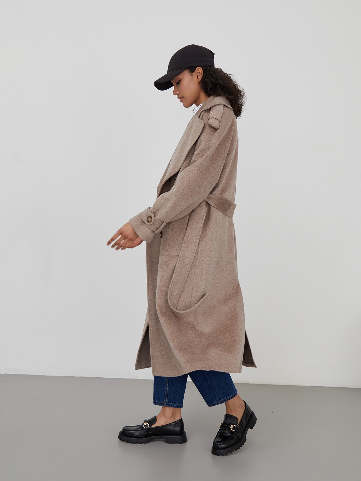 Двубортное пальто-тренч свободного кроя с застежкой на пуговицы. Дополнено поясом, пряжкой на манжетах и погонами в тон изделия. Модный силуэт оверсайз позволяет создавать дерзкие образы в стиле80-х гг.

На модели размер XS