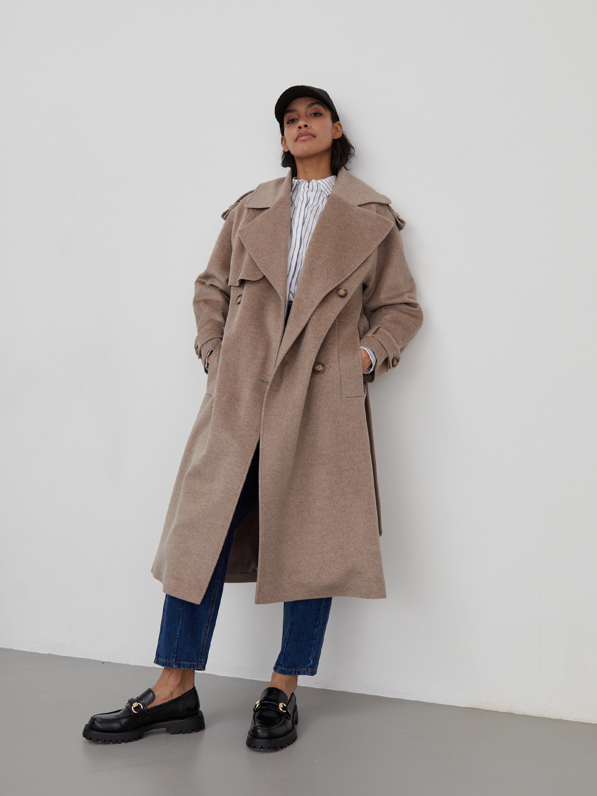 Двубортное пальто-тренч свободного кроя с застежкой на пуговицы. Дополнено поясом, пряжкой на манжетах и погонами в тон изделия. Модный силуэт оверсайз позволяет создавать дерзкие образы в стиле80-х гг.

На модели размер XS