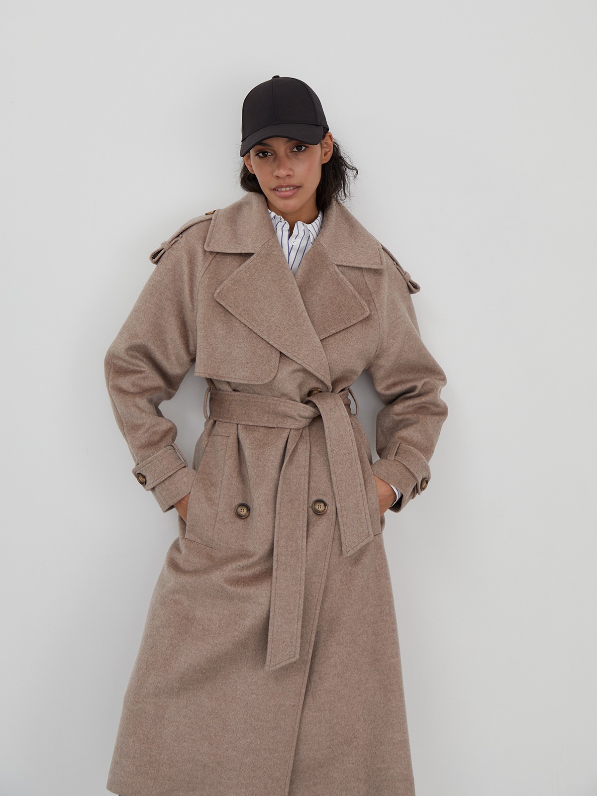 Двубортное пальто-тренч свободного кроя с застежкой на пуговицы. Дополнено поясом, пряжкой на манжетах и погонами в тон изделия. Модный силуэт оверсайз позволяет создавать дерзкие образы в стиле80-х гг.

На модели размер XS