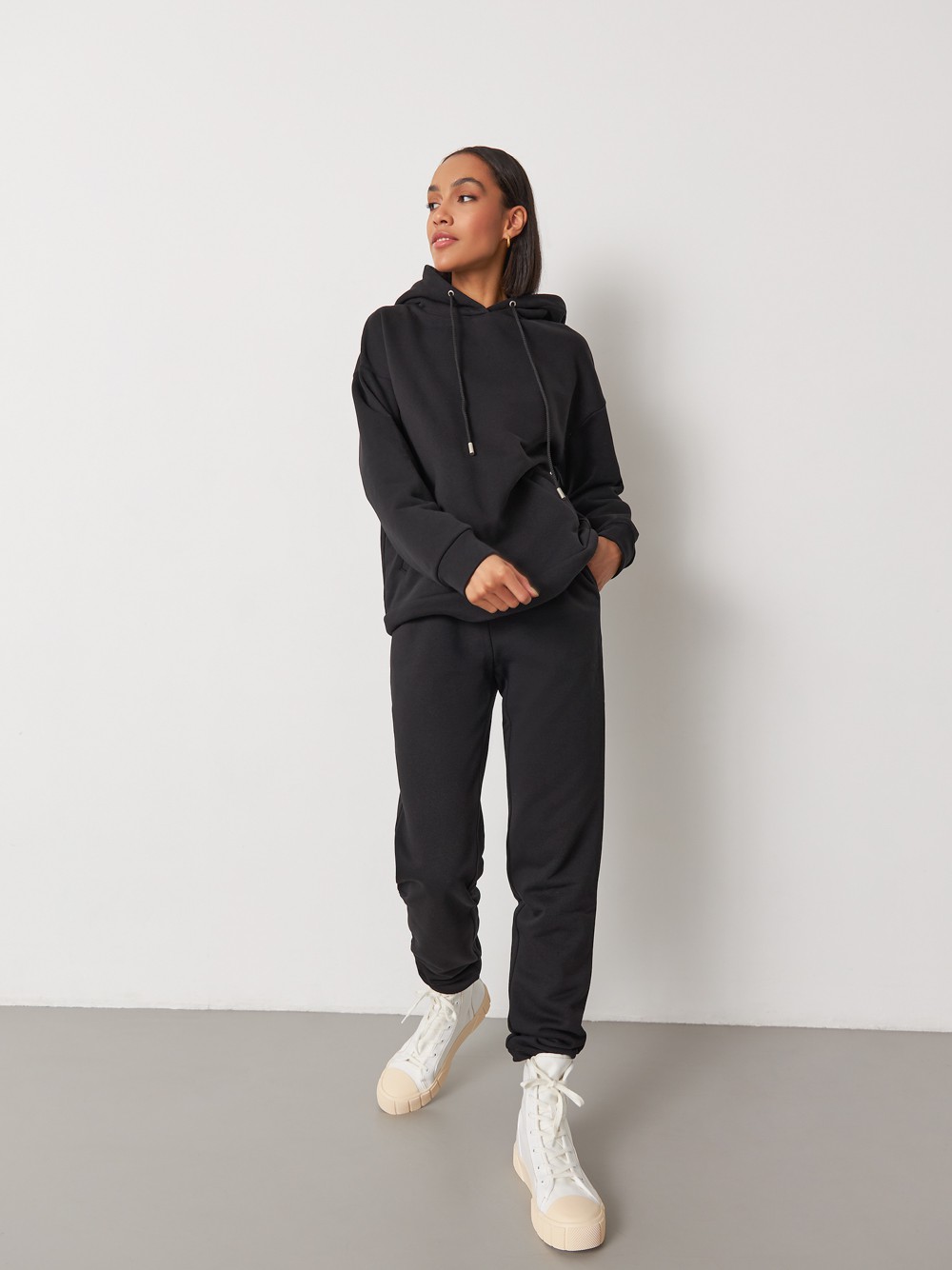 Брюки свободного спортивного силуэта. Модель дополнена манжетами из основной ткани по низу изделия и карманами по боковым швам. На поясе у брюк пояс, регулируемый завязками. Дополните свой образ толстовкой в тон изделия.

На модели размер XS