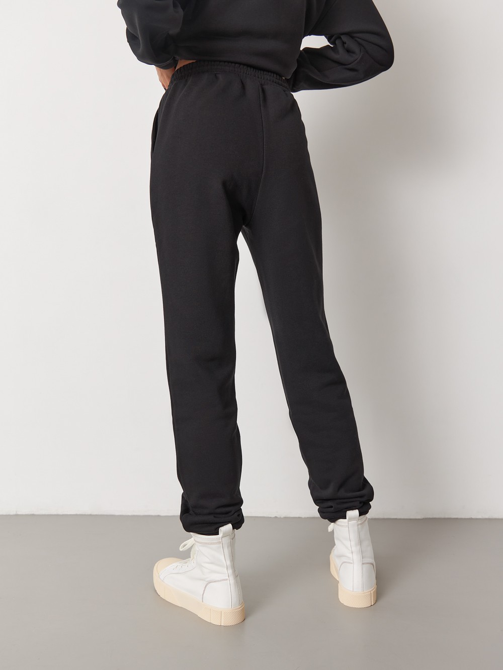 Брюки свободного спортивного силуэта. Модель дополнена манжетами из основной ткани по низу изделия и карманами по боковым швам. На поясе у брюк пояс, регулируемый завязками. Дополните свой образ толстовкой в тон изделия.

На модели размер XS