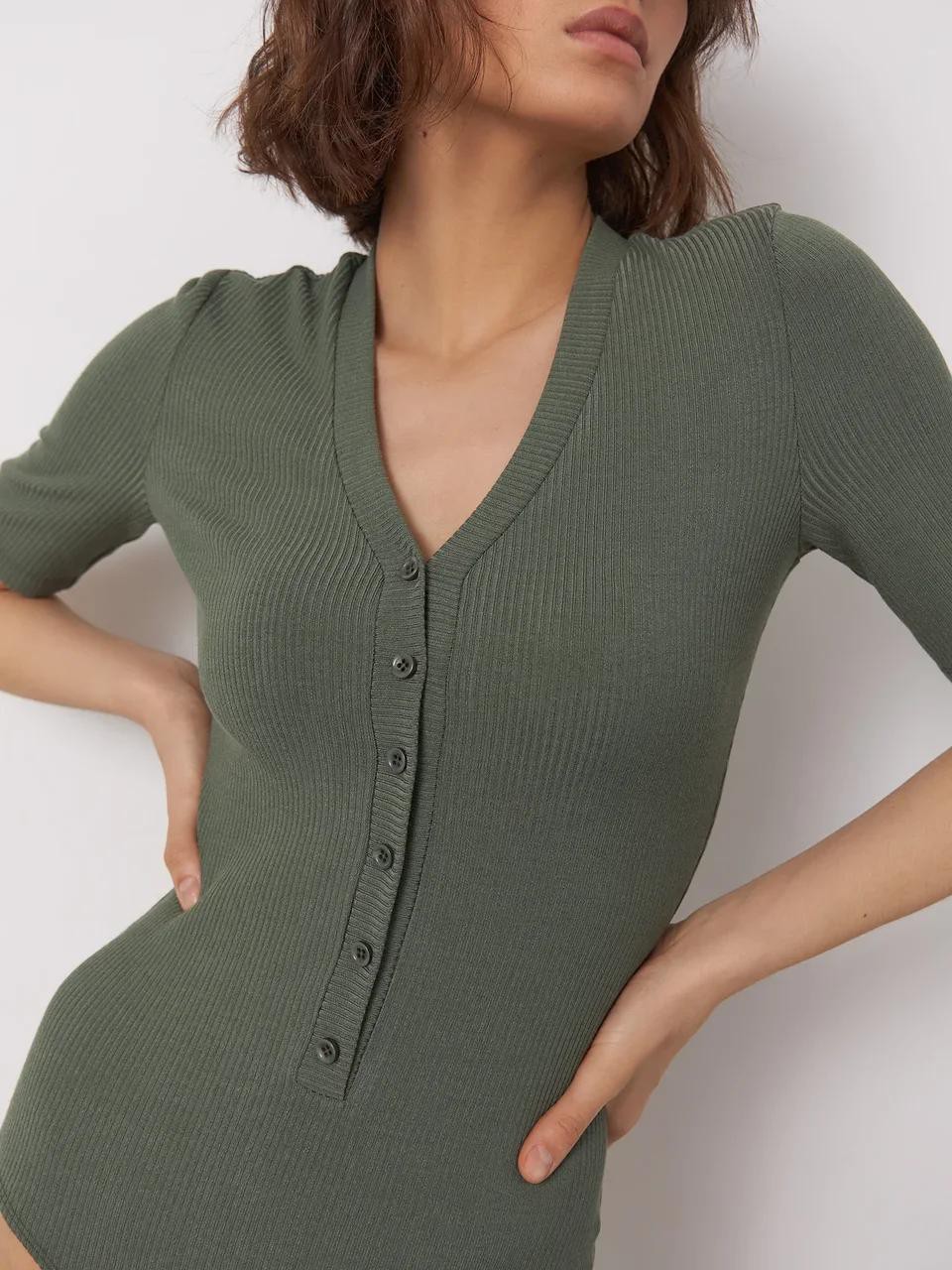 




Трикотажное боди с V-образным декольте, коротким рукавом и застежкой на пуговицы. Универсальный фасон и отличное вложение в базовый гардероб. Текстурный рубчик добавляет этому лаконичному боди визуальной глубины. Сочетайте его с прямыми брюками в тон для сбалансированного вытянутого силуэта.

На модели размер XS