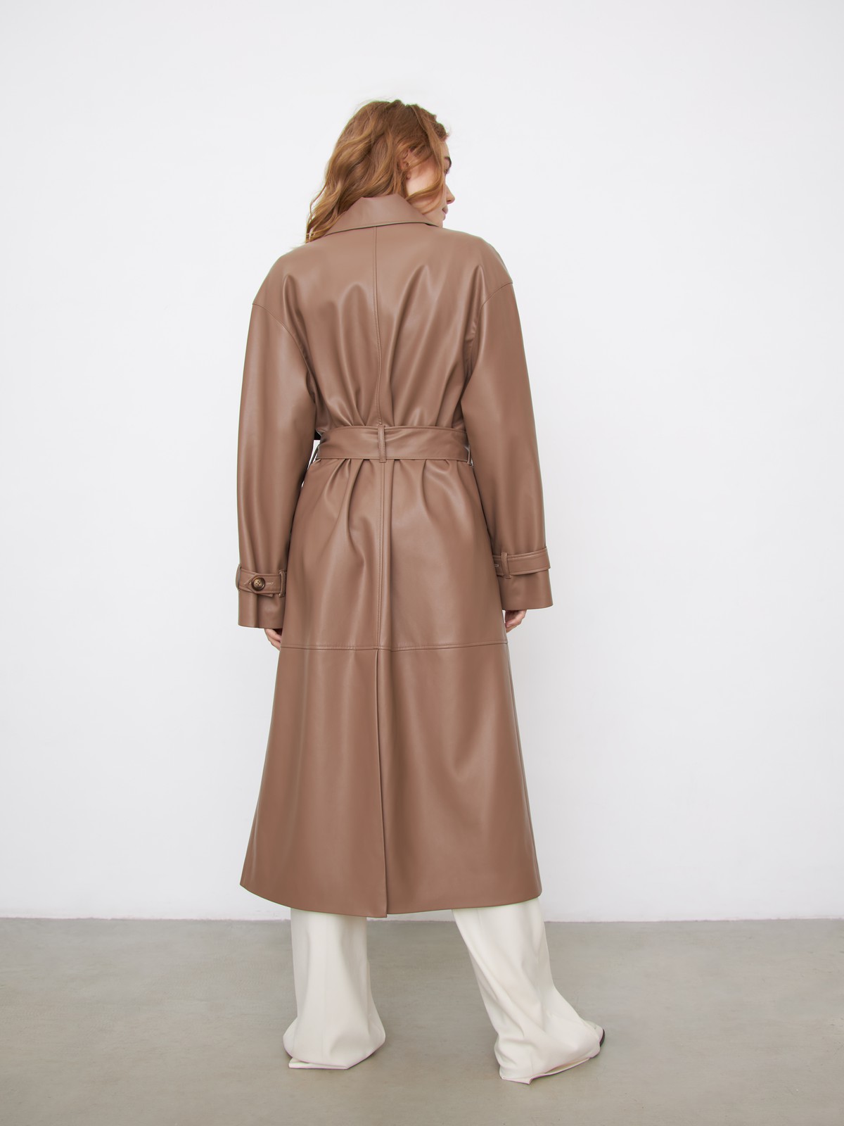 Двубортный плащиз эко-кожи - новая классика современного гардероба. Модель свободной посадки акцентирована отлетными деталями, поясом на талии и скошенными прорезными карманами с широкими листочками.

На модели размер XS/S