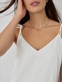Топ в бельевом стиле оформлен аккуратным V-вырезом и тонкими бретельками на завязках. Универсальный выбор при создании повседневного, офисного и образа для выхода в свет. Сочетайте с юбкой в тон и лаконичными украшениями.

На модели размер XS
