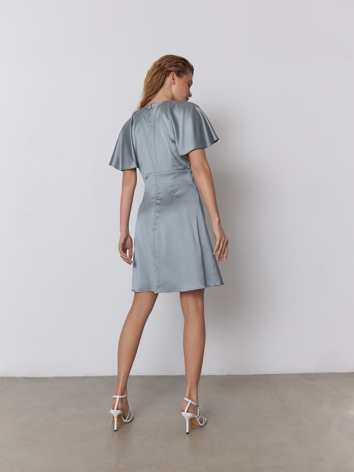 


Платье мини из атласной ткани оформлено юбкой А-силуэта. V-образный вырез с мягкими сборками по линии декольте и рукава-крылышки добавляют модели дополнительной нежности.

На модели размер XS