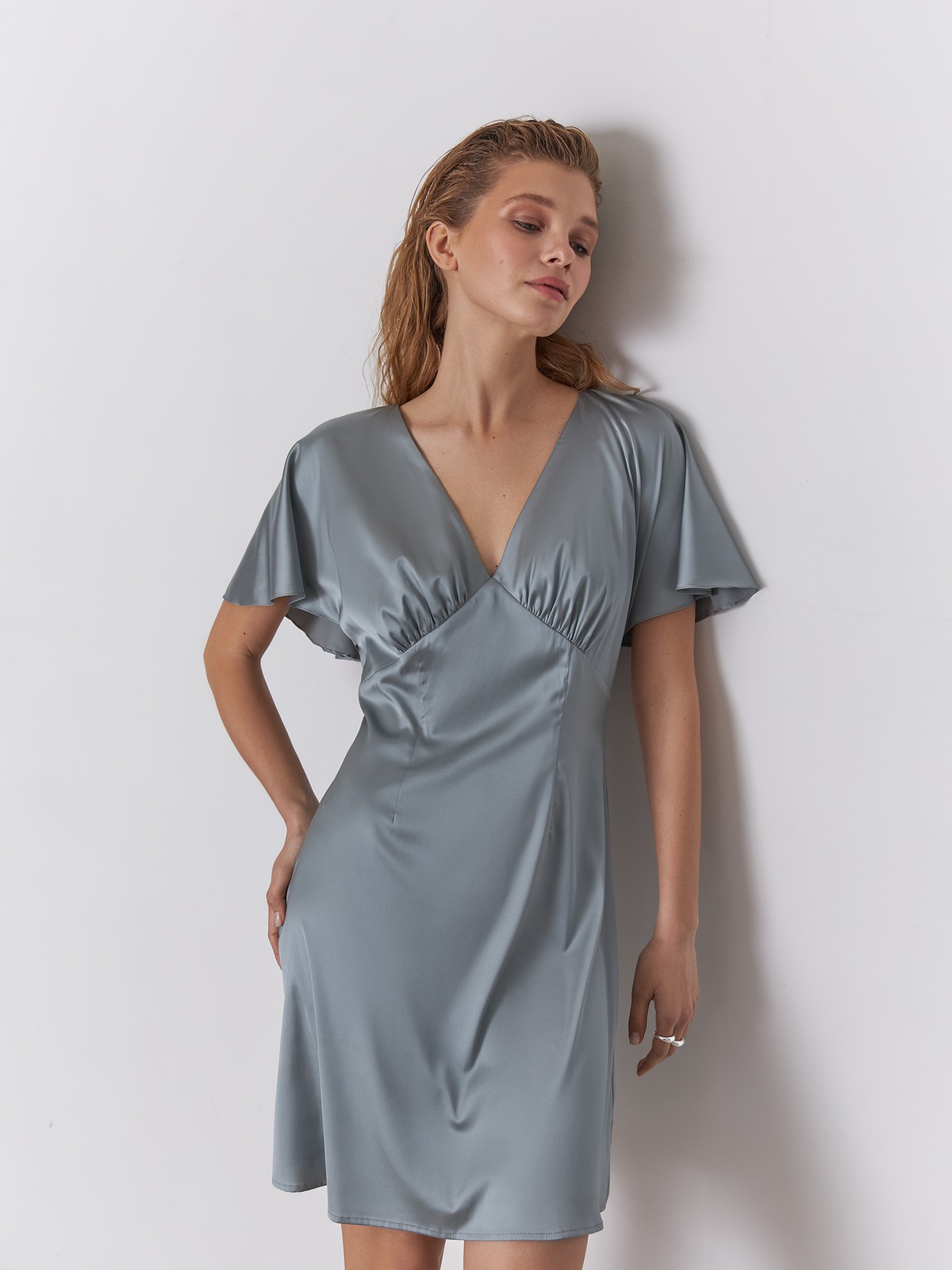 


Платье мини из атласной ткани оформлено юбкой А-силуэта. V-образный вырез с мягкими сборками по линии декольте и рукава-крылышки добавляют модели дополнительной нежности.

На модели размер XS