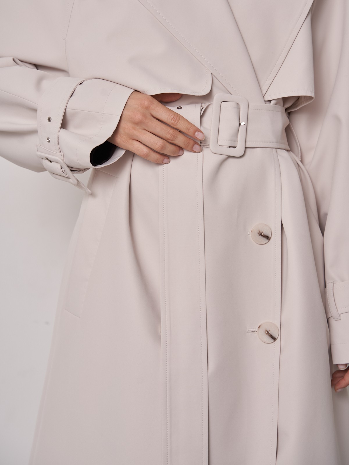 Плащдвубортного кроя с застежкой на крупные однотонные пуговицы. Отлетная кокетка, А-силуэт и длинный пояс на талии добавляют образу легкости, а цветовая гамма создает поистине весеннее настроение.

На модели размер M\L