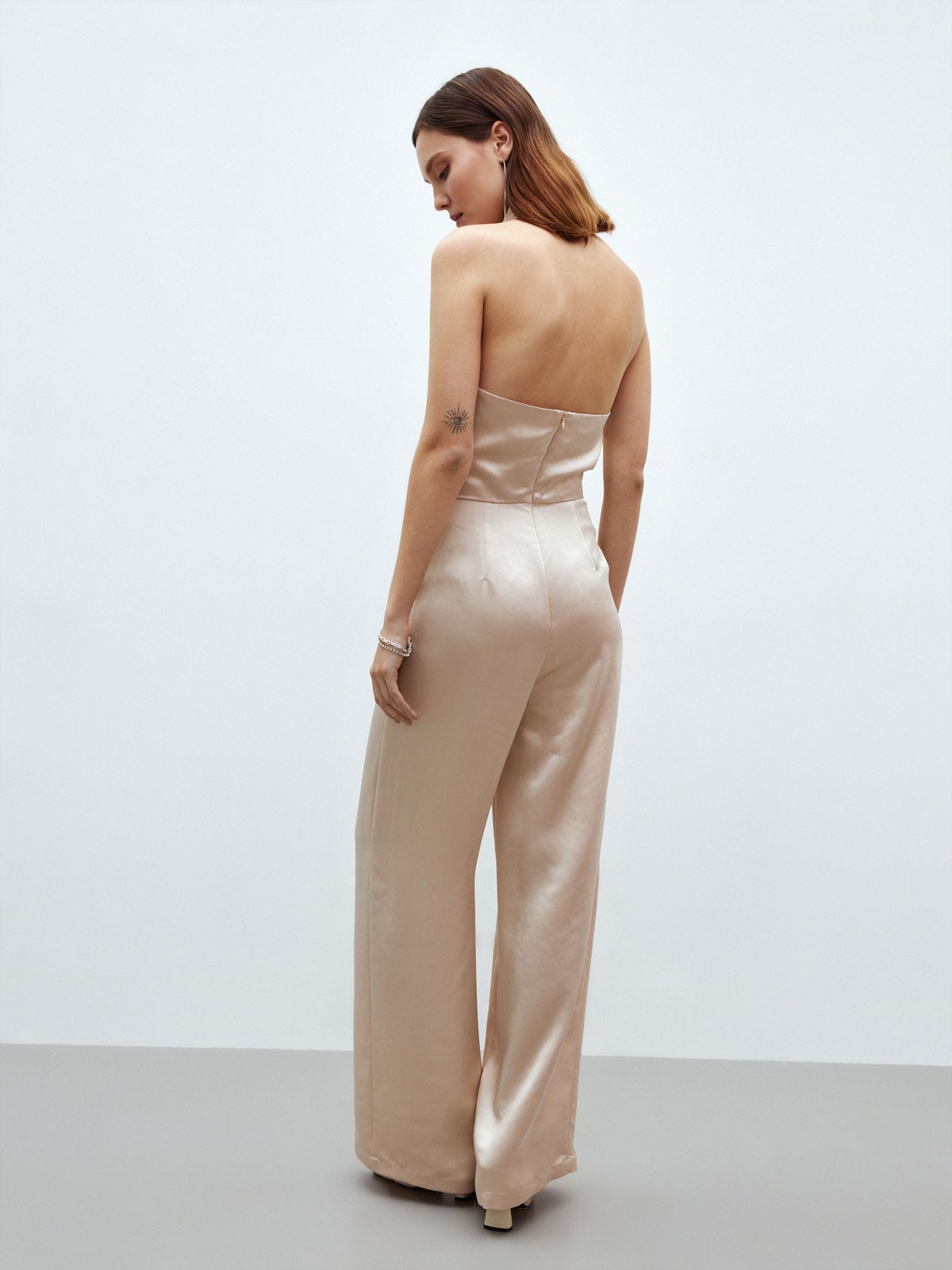 


Комбинезон с открытой спиной. Состоит из топа с креплением на пуговицы и широких брюк в пол. Брюки с высокой талией. Изысканная струящаяся ткань с деликатным блеском. Застежка с потайной молнией на спине. Подкладочная тканьв районе груди и два кармана на брюках, чтобы положить помаду и телефон. Рекомендуем носить самостоятельно, когда хочется произвести фурор на вечеринке.

На модели размер XS