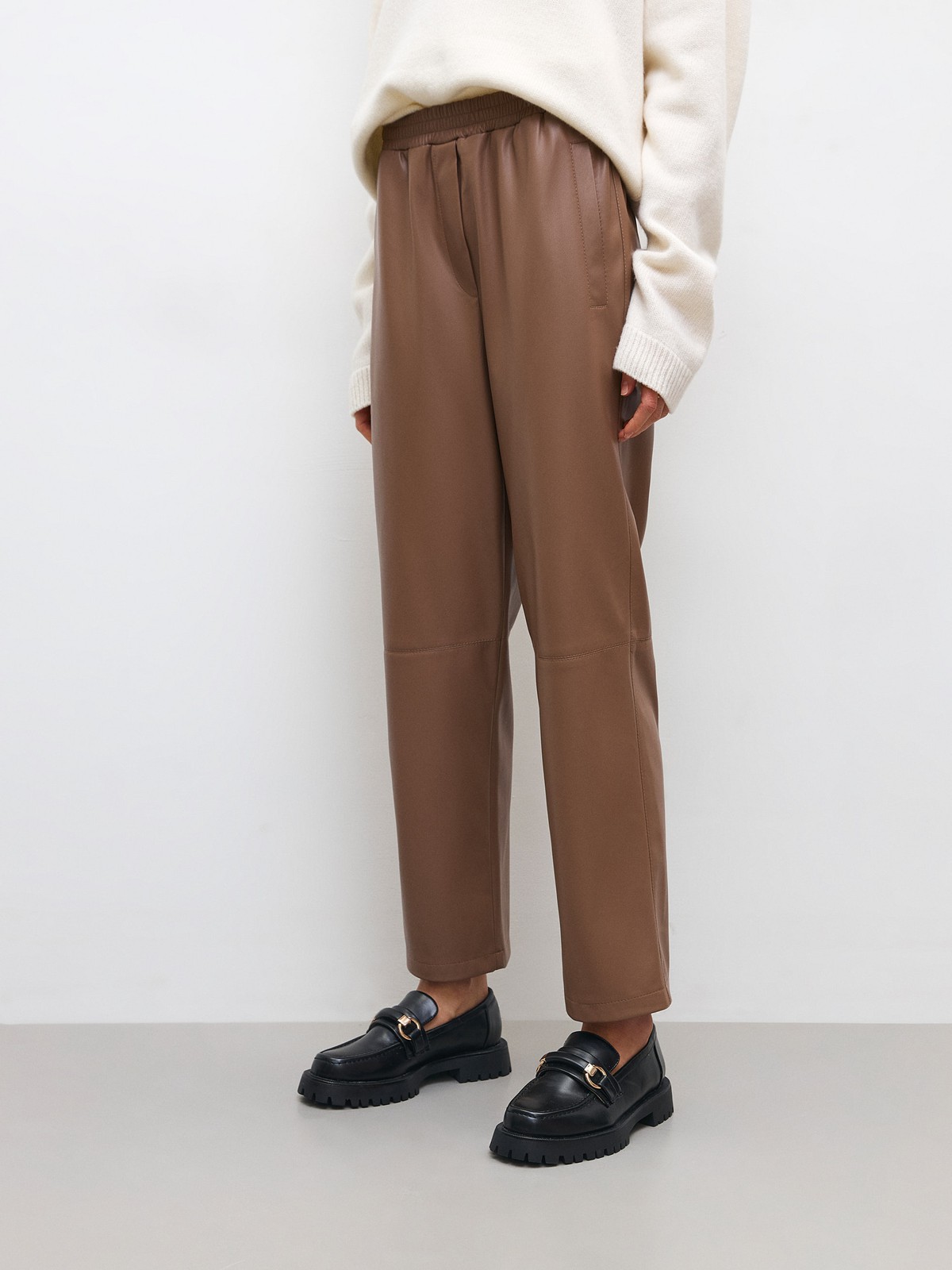 


Широкие брюки из экокожи. Посадка на резинке, благодаря чему вы можете регулировать линию талии по желанию. Шов в районе колена для объема. Два кармана, куда можно положить телефон и ключи. Мы предлагаем сочетать брюки с рубашкой из экокожи или создать контраст фактур.

На модели размер XS