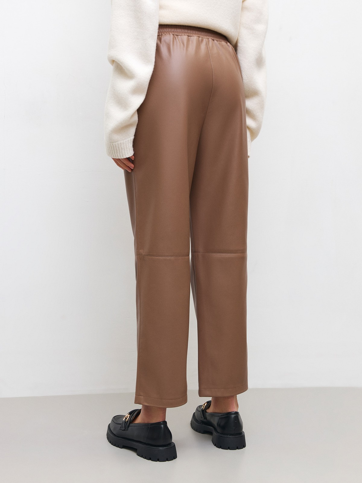 


Широкие брюки из экокожи. Посадка на резинке, благодаря чему вы можете регулировать линию талии по желанию. Шов в районе колена для объема. Два кармана, куда можно положить телефон и ключи. Мы предлагаем сочетать брюки с рубашкой из экокожи или создать контраст фактур.

На модели размер XS