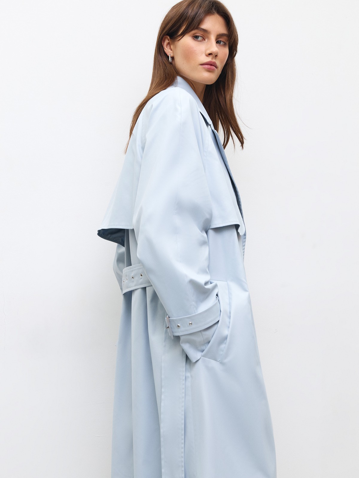 Тренч, цвет: серо-голубой Allweneed Плащдвубортного кроя с застежкой на крупные однотонные пуговицы. Отлетная кокетка, А-силуэт и длинный пояс на талии добавляют образу легкости, а цветовая гамма создает поистине весеннее настроение.