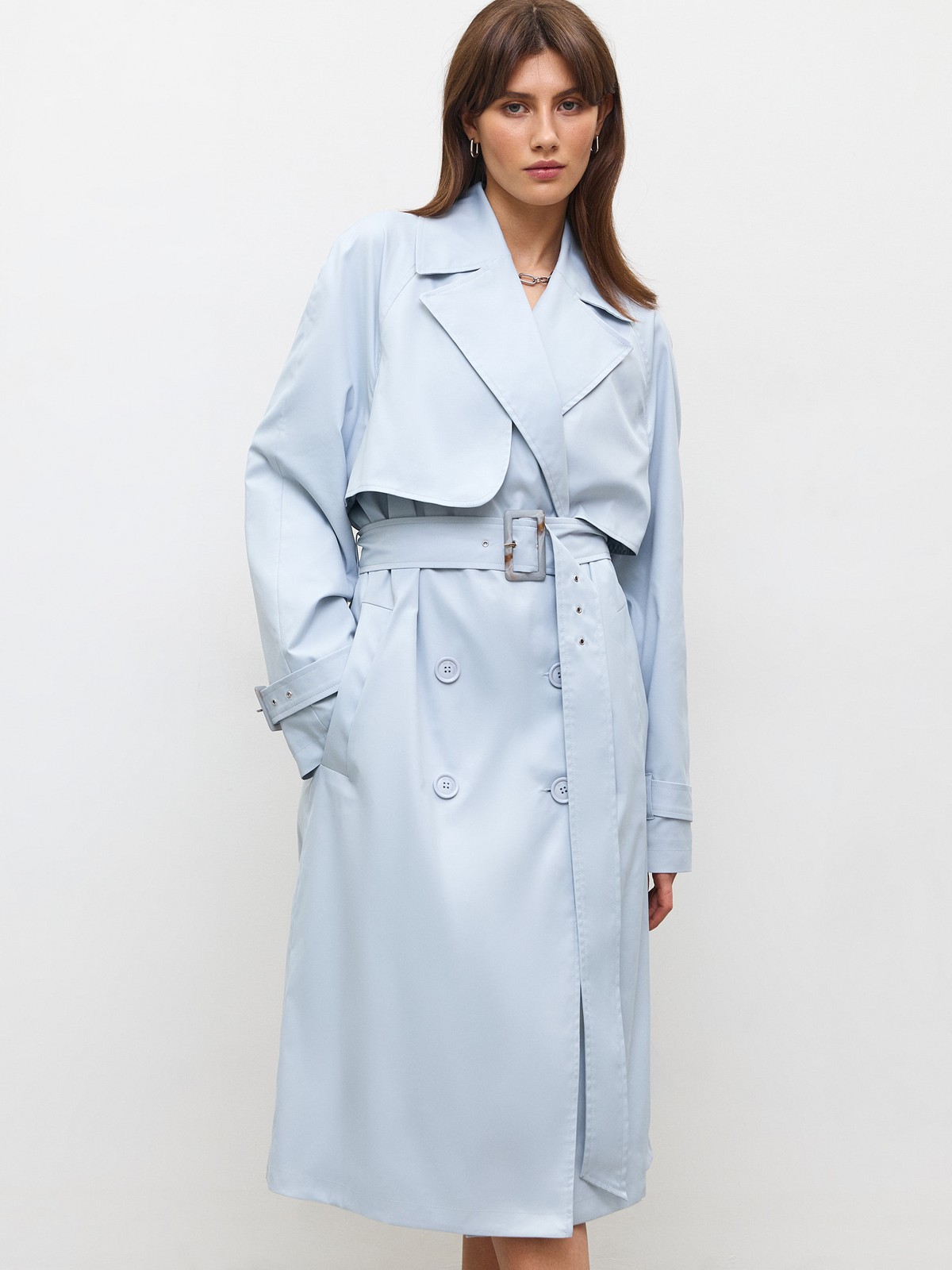 Тренч, цвет: серо-голубой Allweneed Плащдвубортного кроя с застежкой на крупные однотонные пуговицы. Отлетная кокетка, А-силуэт и длинный пояс на талии добавляют образу легкости, а цветовая гамма создает поистине весеннее настроение.