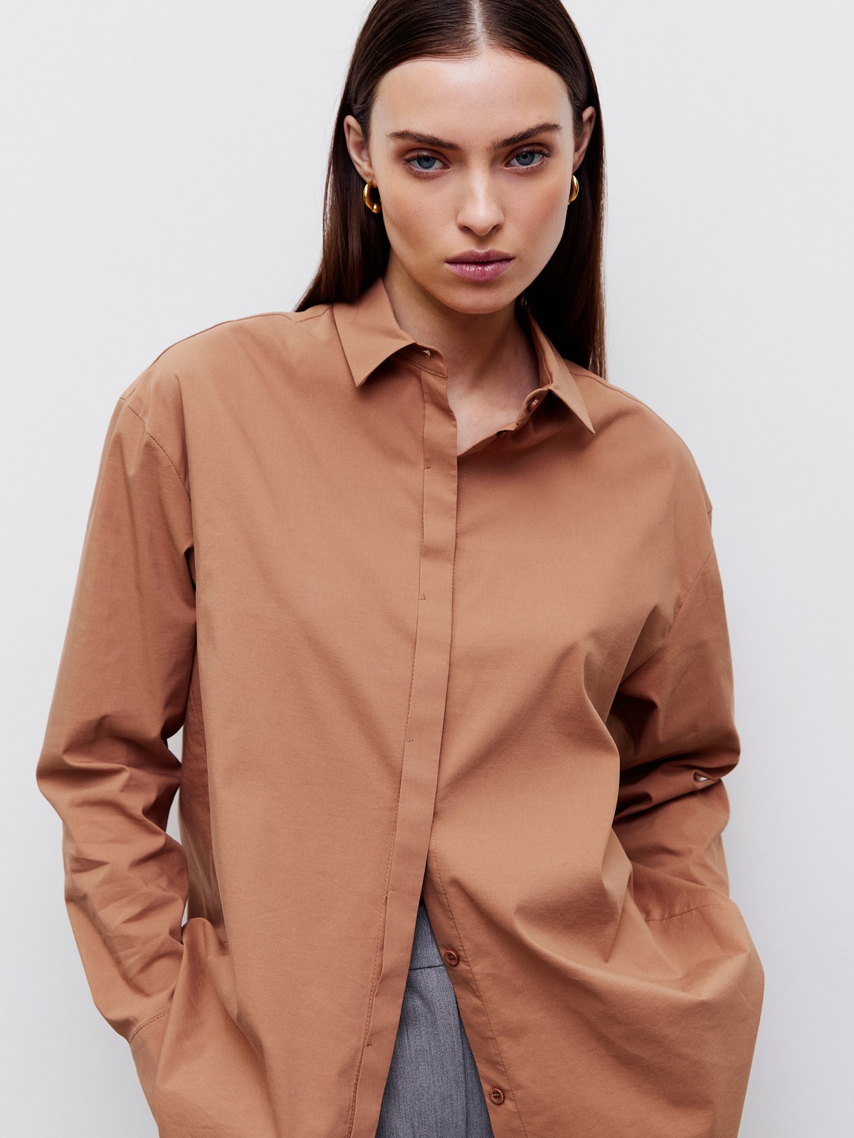 Рубашка oversize, цвет: светло- коричневый Allweneed Рубашка oversize кроя с отложным воротником изастежкой на пуговицы. Длинные рукава с классическими манжетами. Слегка удлиненная спинка. Носите навыпуск или заправленной в контрастную юбку, шорты или брюки.